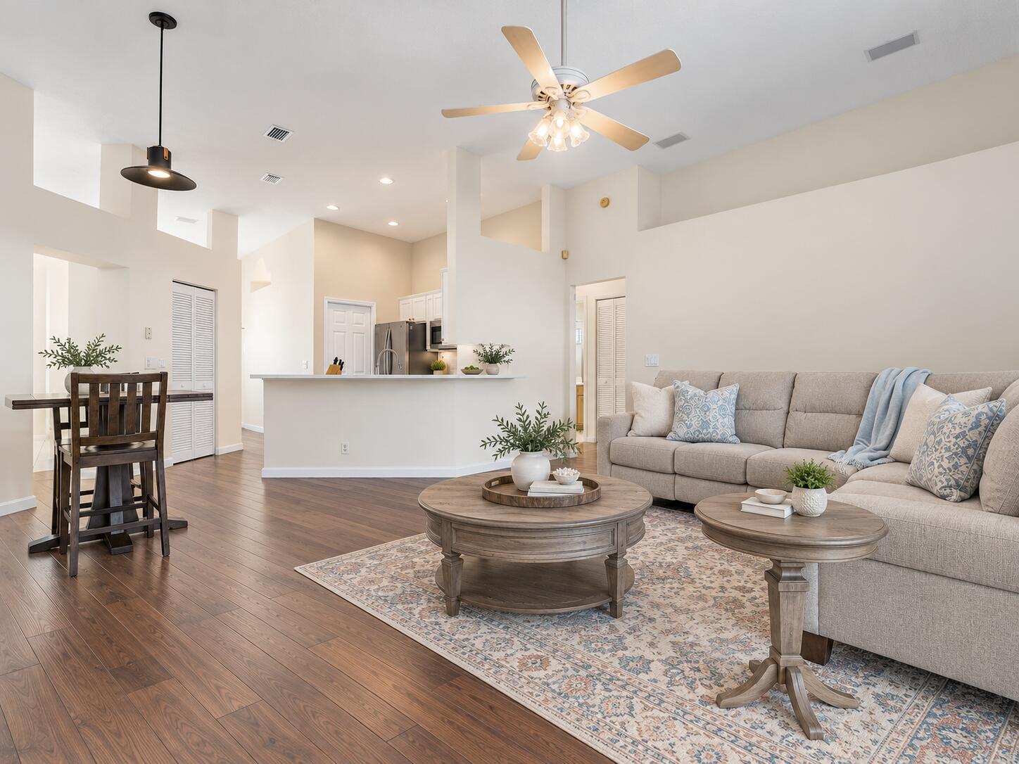 VIRTUALLY STAGED. Family room and kitchen shown with digital furniture, paint and floors to illustrate possible updates.