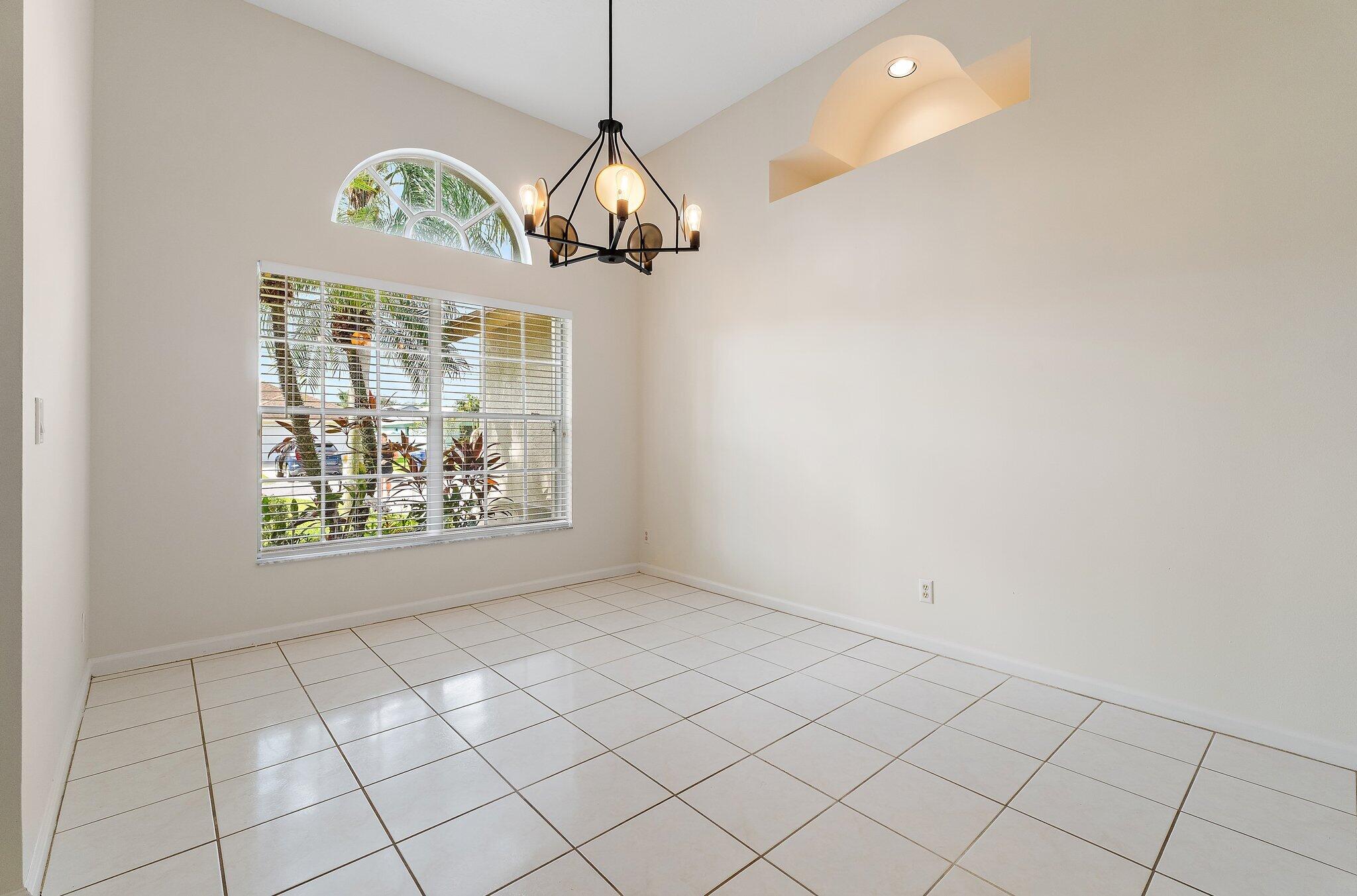 Dining room with a chandelier and arched windows.
