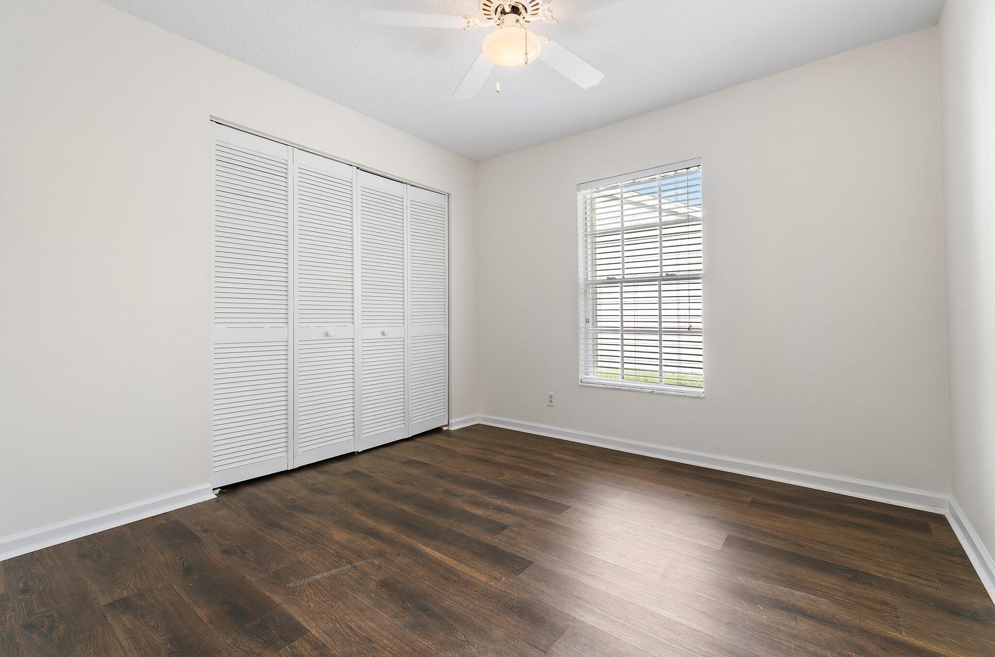 Guest bedroom with wood-look floors and a double closet.