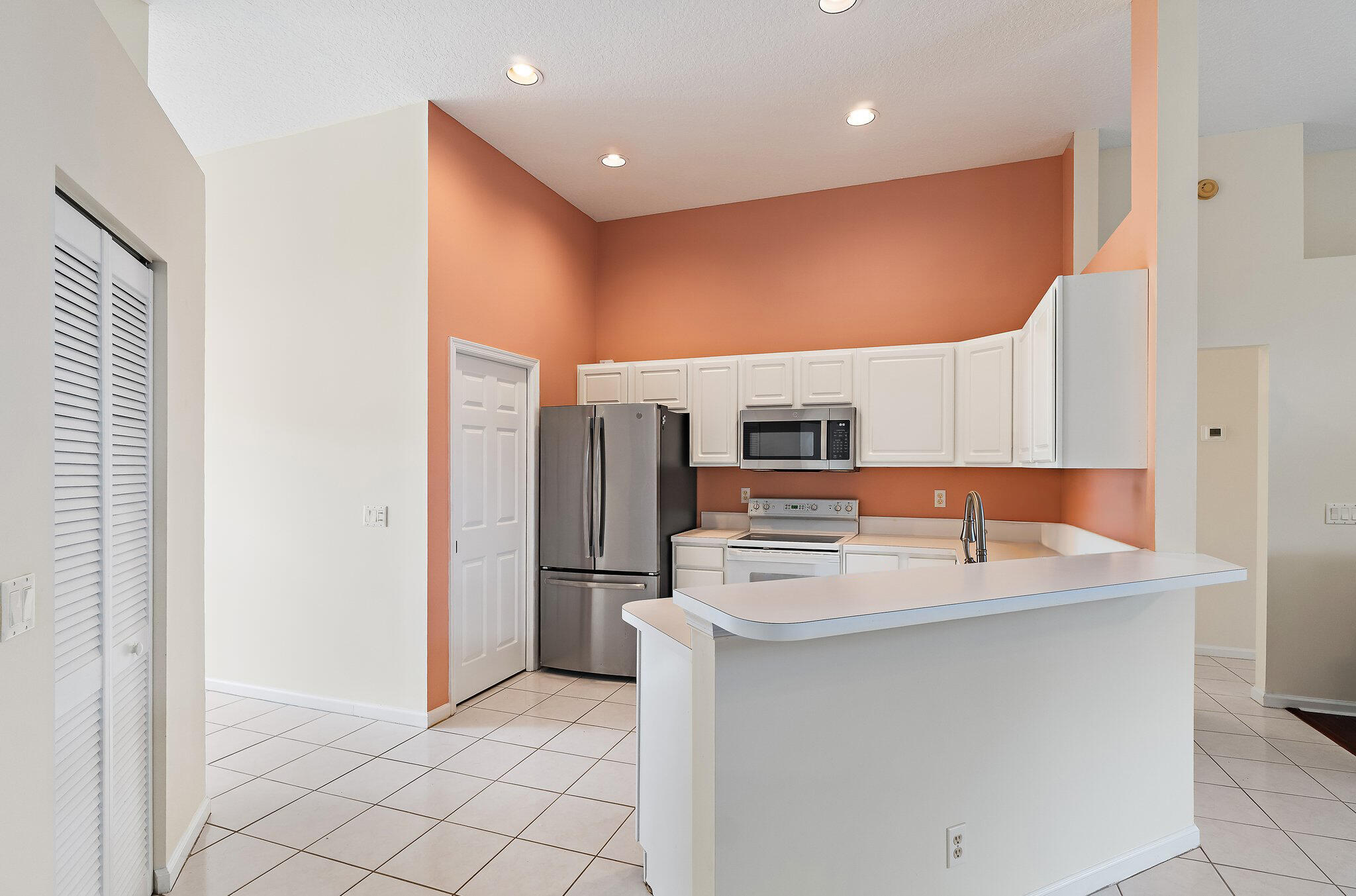 Kitchen with white cabinetry and a stainless refrigerator.