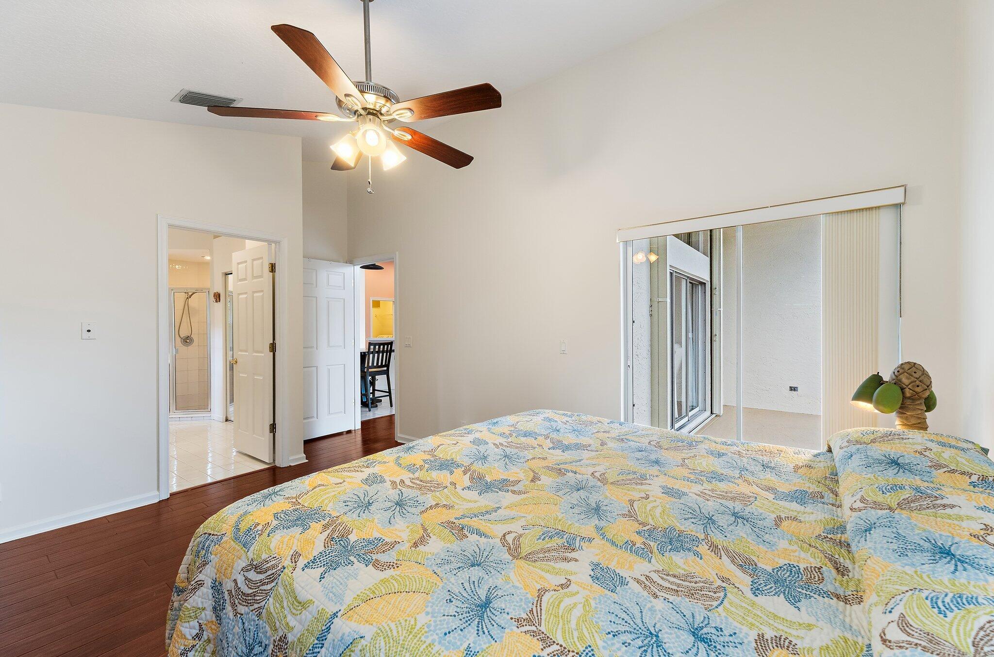 Primary bedroom with sliding glass doors to the screened patio.