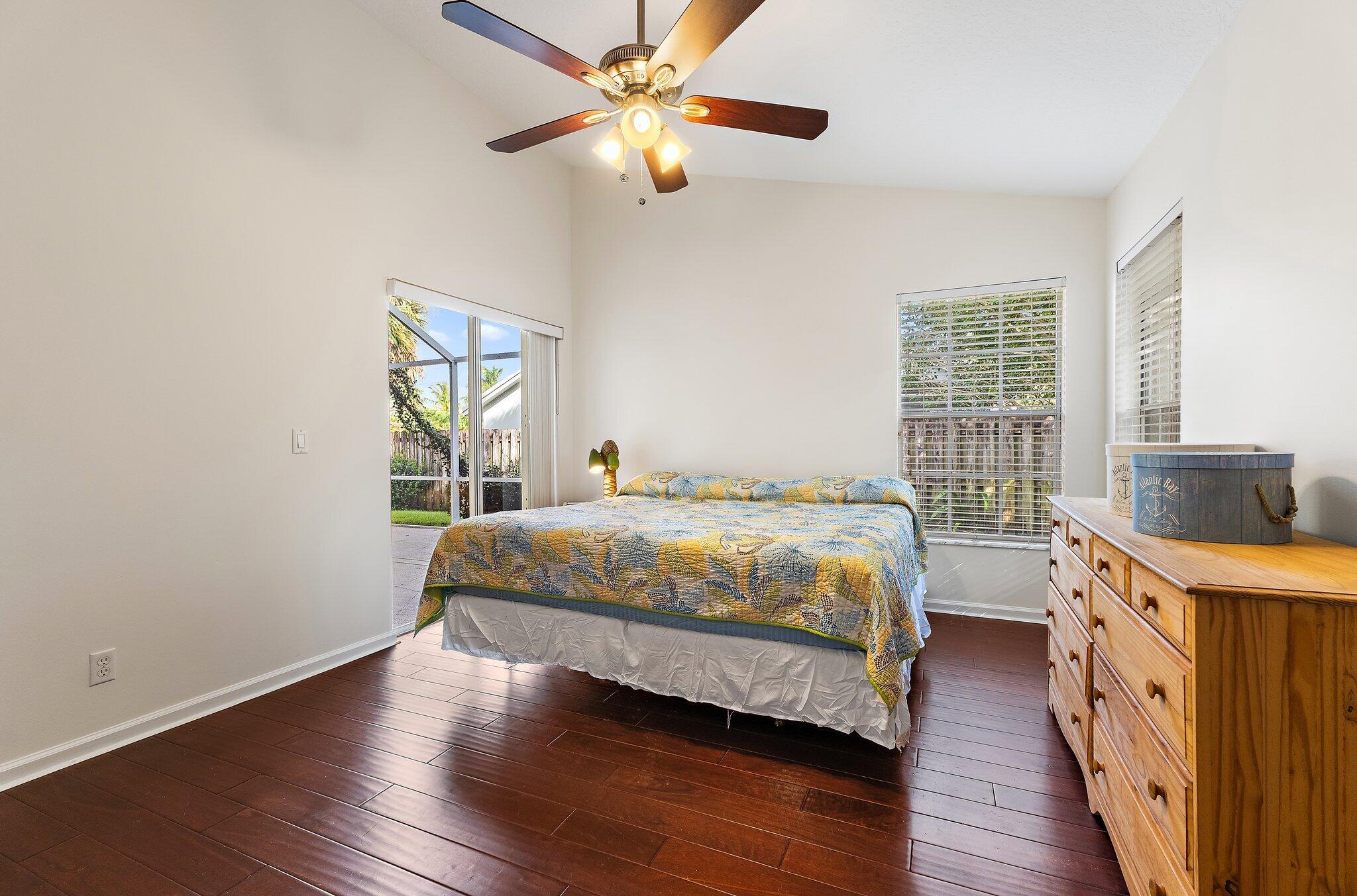 Primary bedroom with wood floors and natural light.
