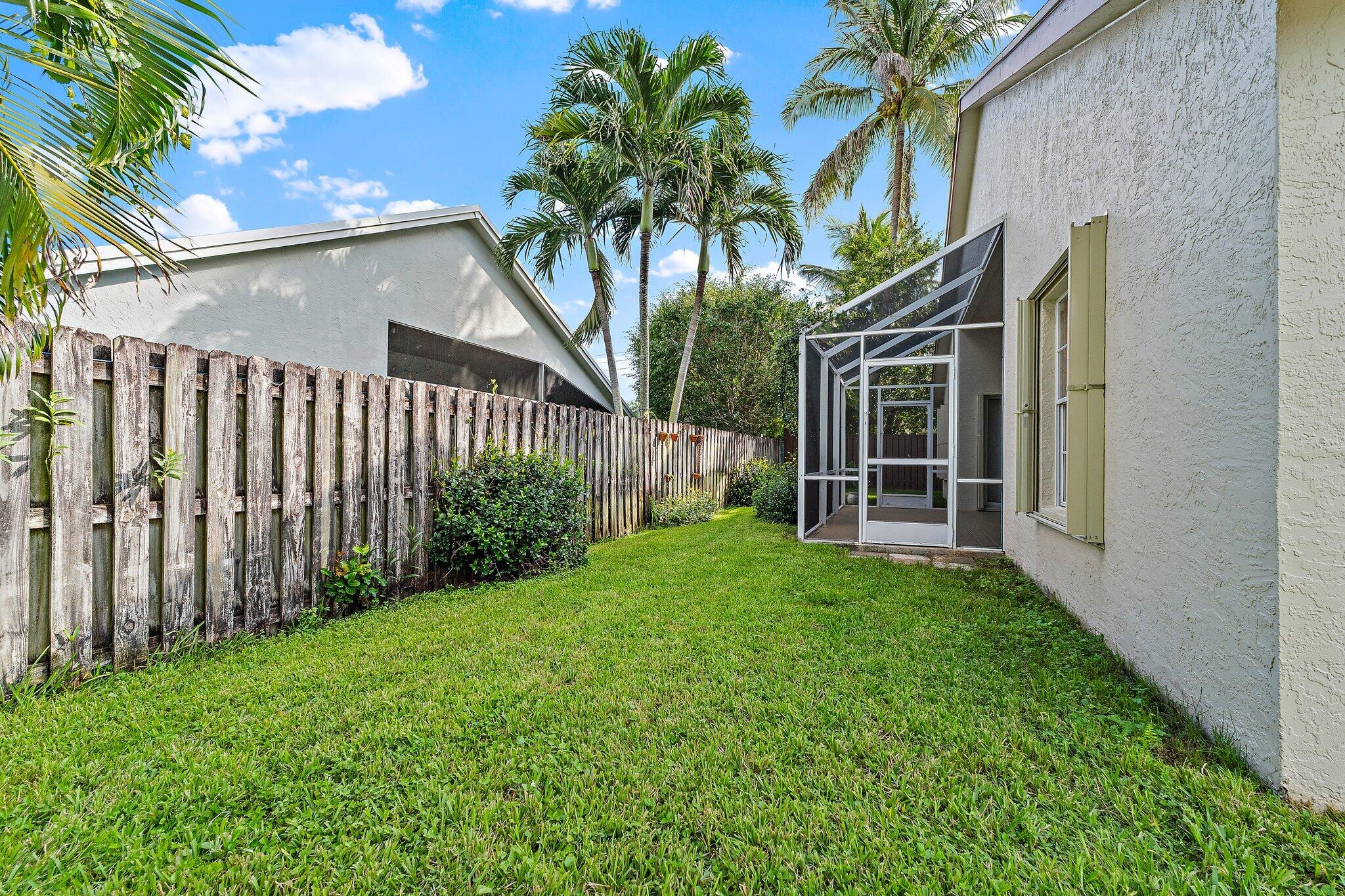Fenced side yard with tropical landscaping.