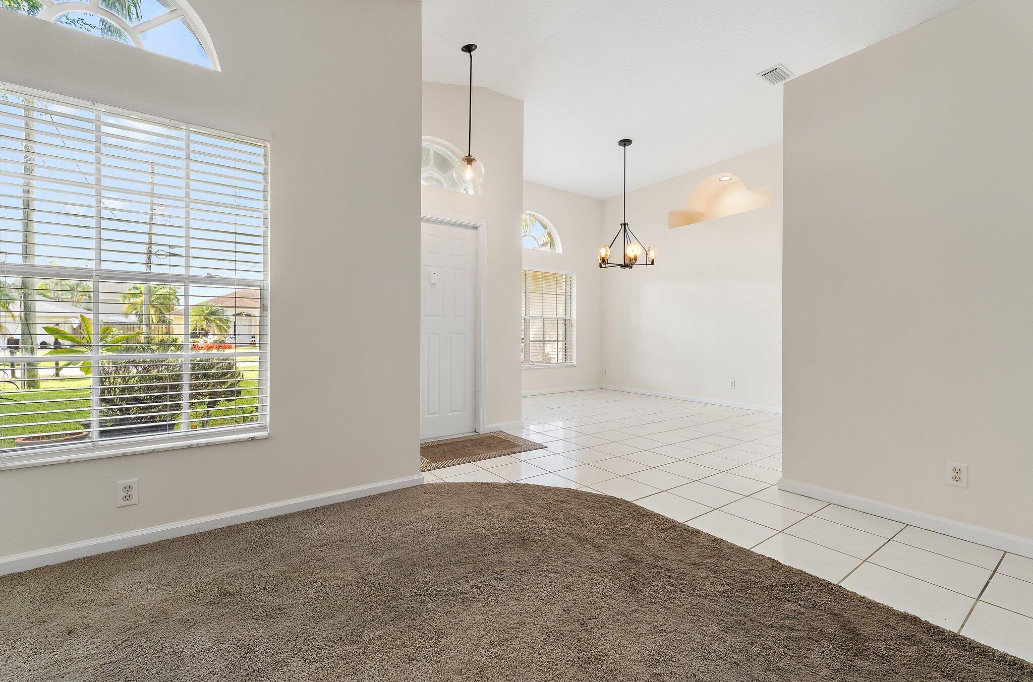 Living room with high ceilings, open to the dining area.