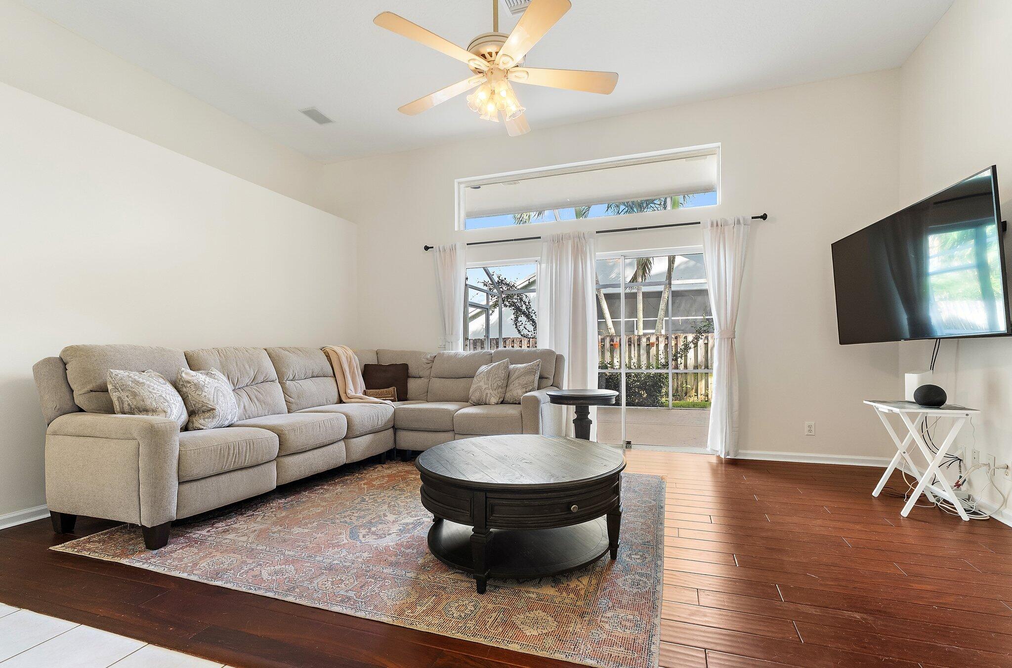 Family room with wood floors and glass doors to the screened patio.