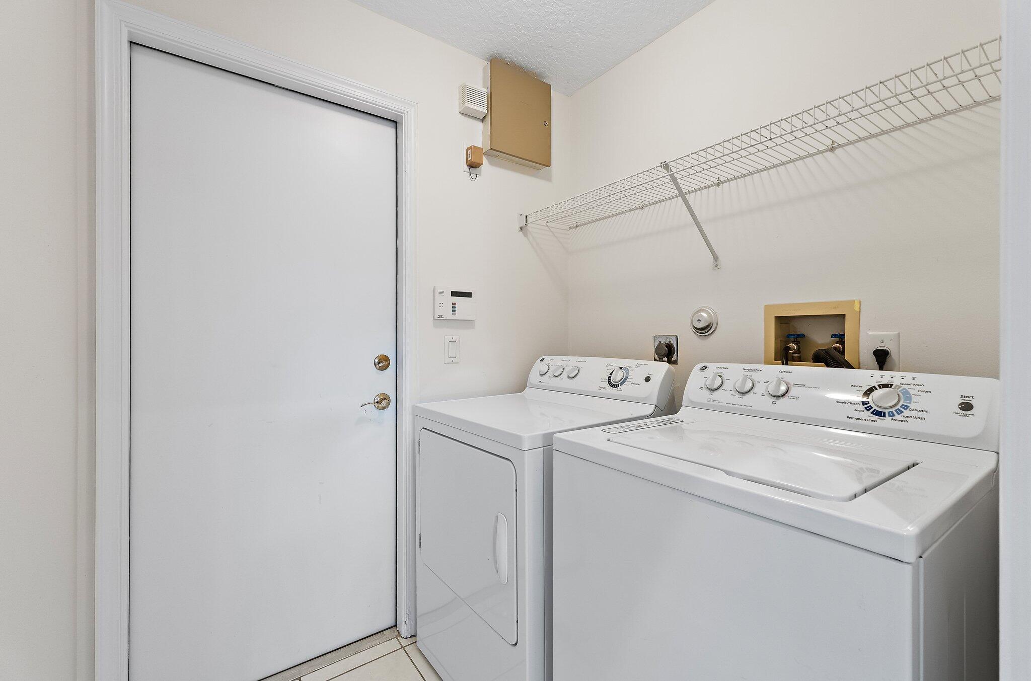 Laundry room with washer, dryer and shelving.