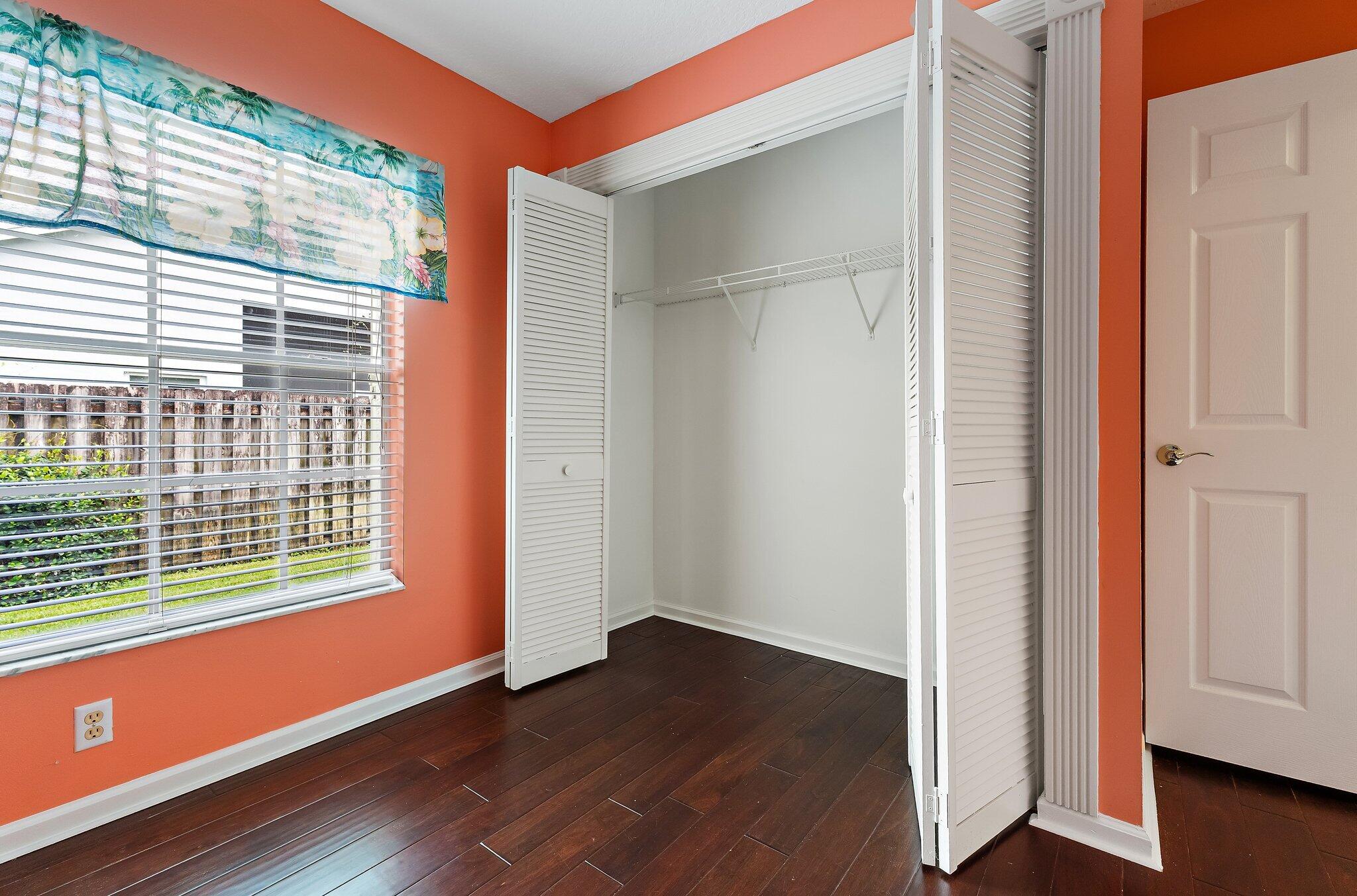 Guest bedroom with wood floors and a closet.