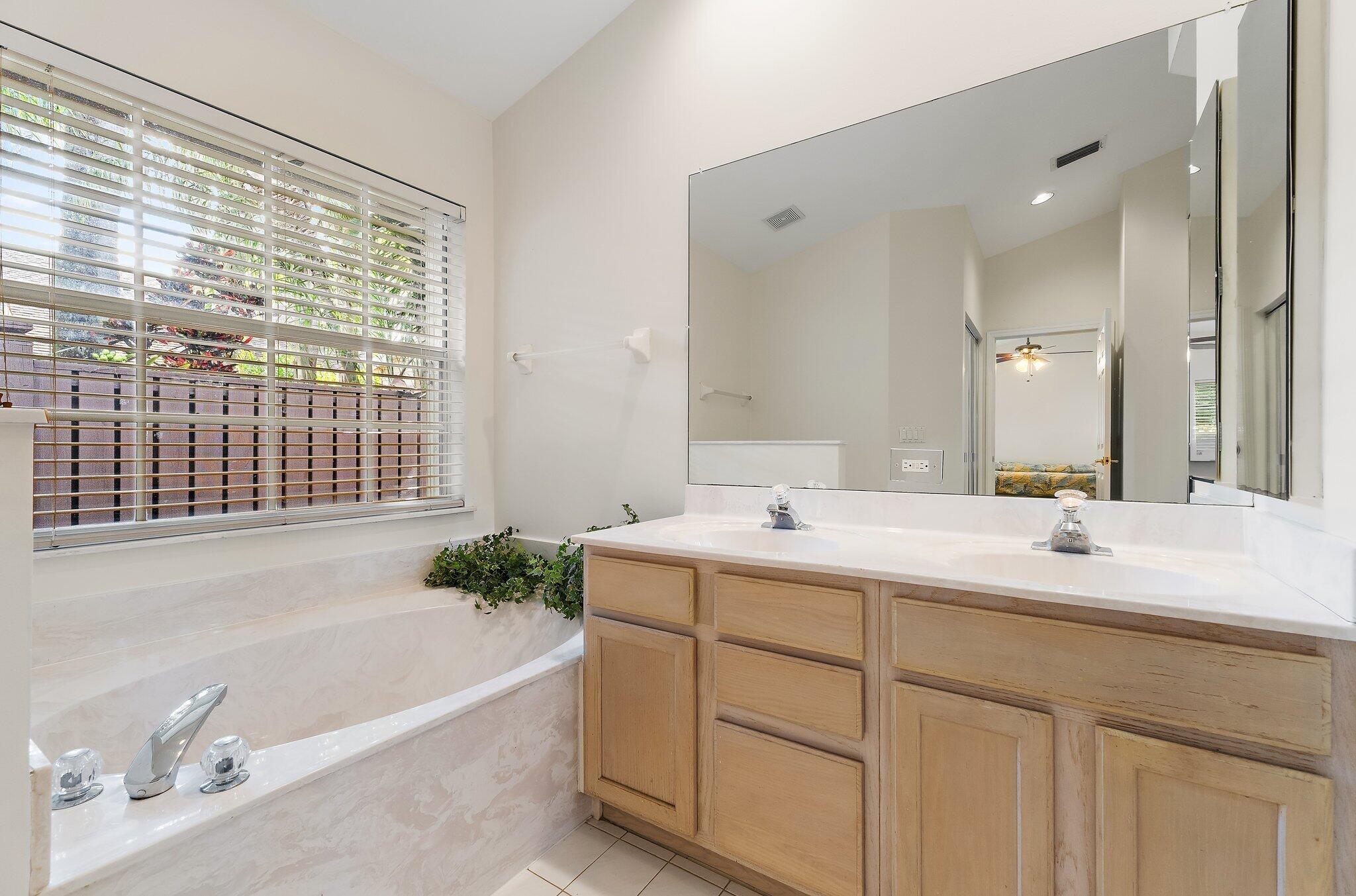 Primary bath with a long vanity and soaking tub.