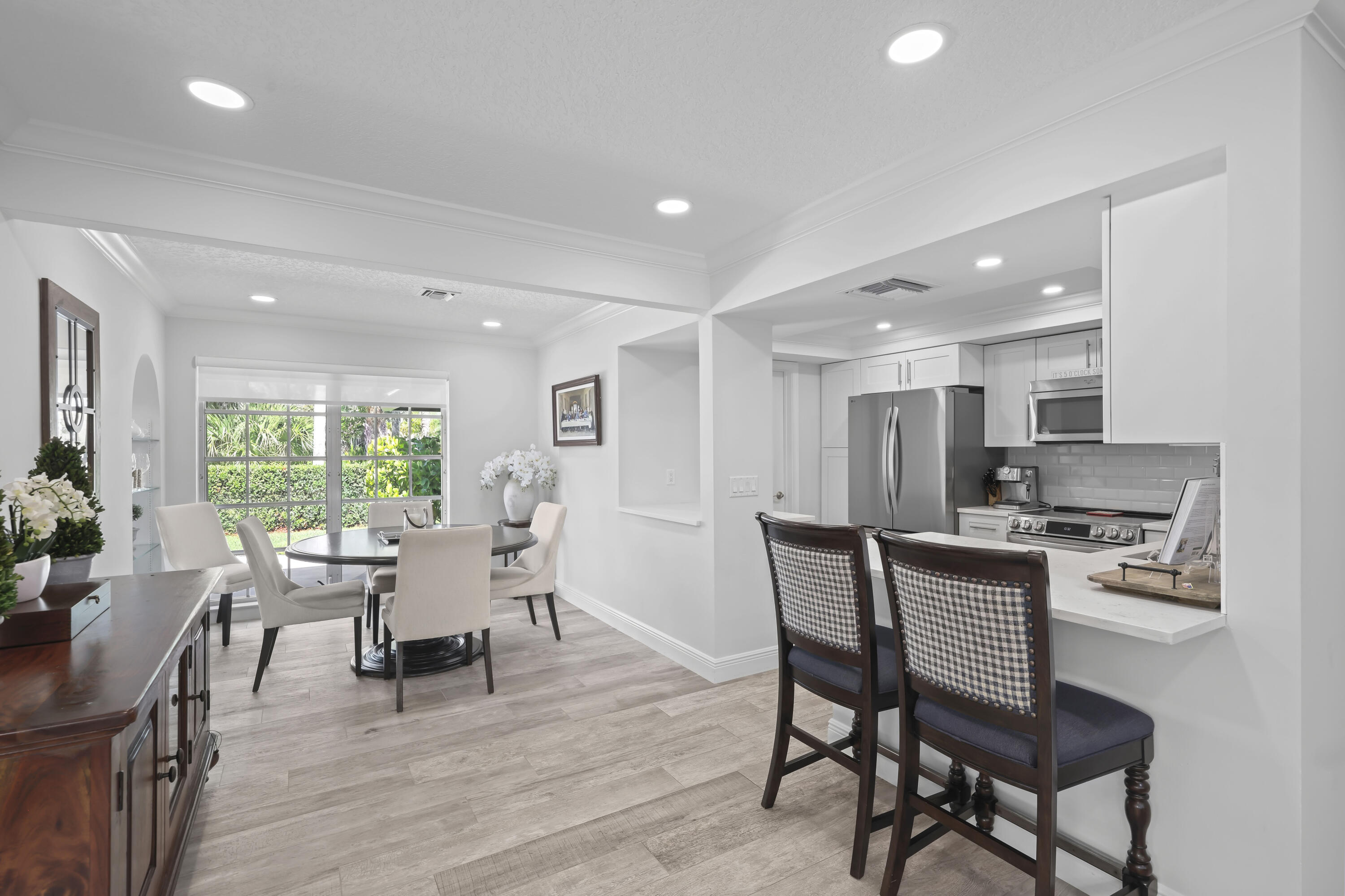 Kitchen featuring wood-finish flooring, recessed lighting, stainless steel appliances, stone-surface countertops, and breakfast bar seating