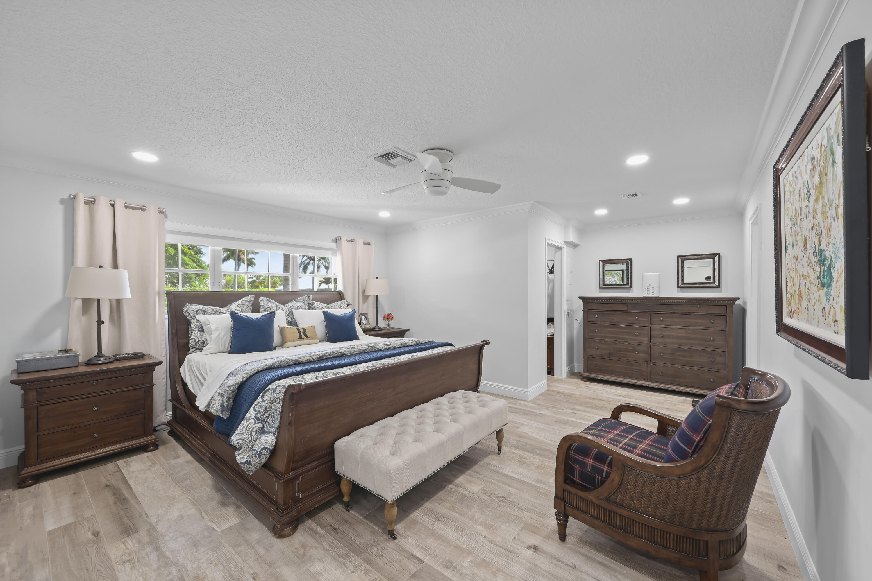 Spacious room featuring wood-finish flooring, recessed lighting, and a ceiling fan