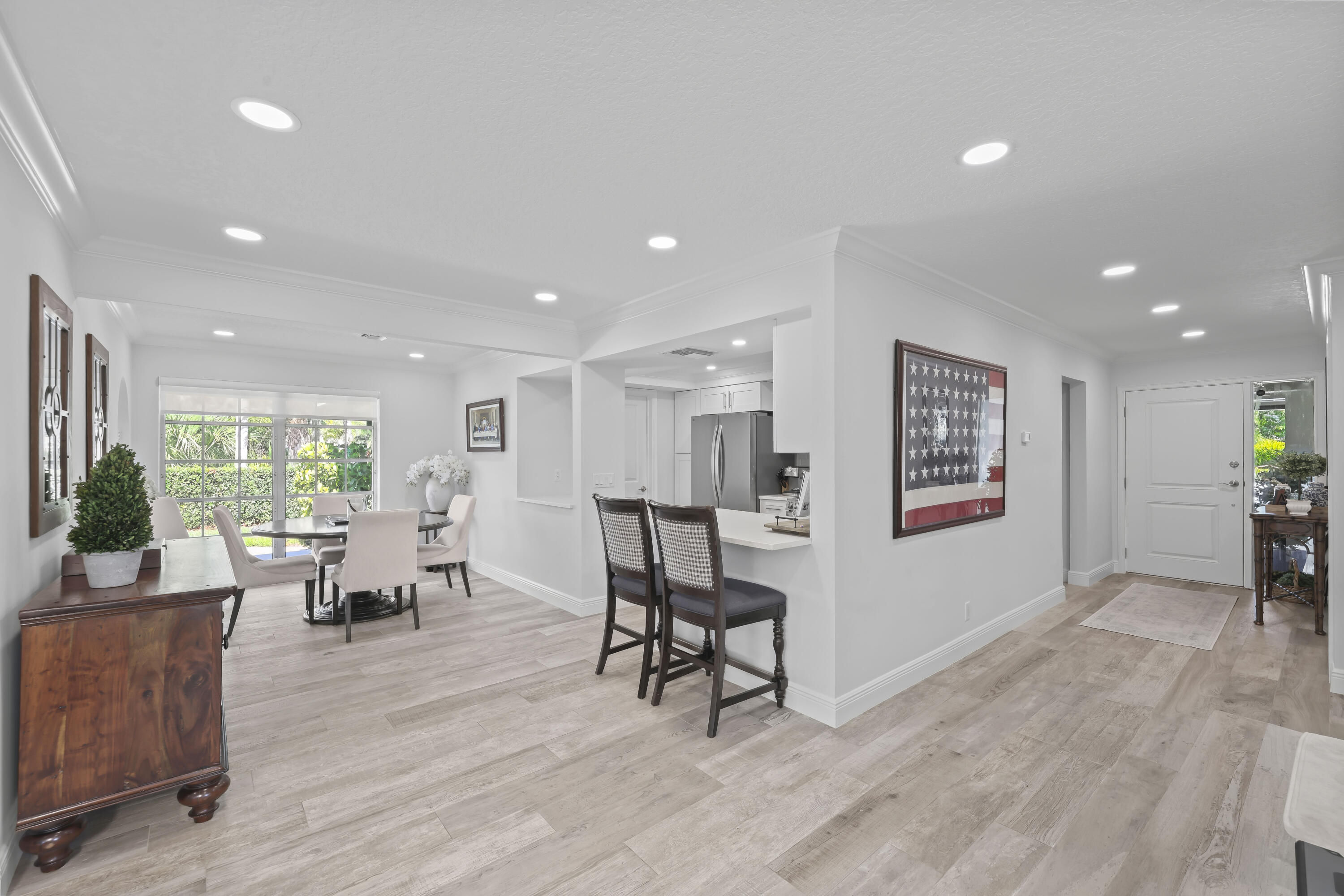 Open interior space featuring wood-finish flooring, recessed lighting, and a kitchen breakfast bar with solid-surface countertop