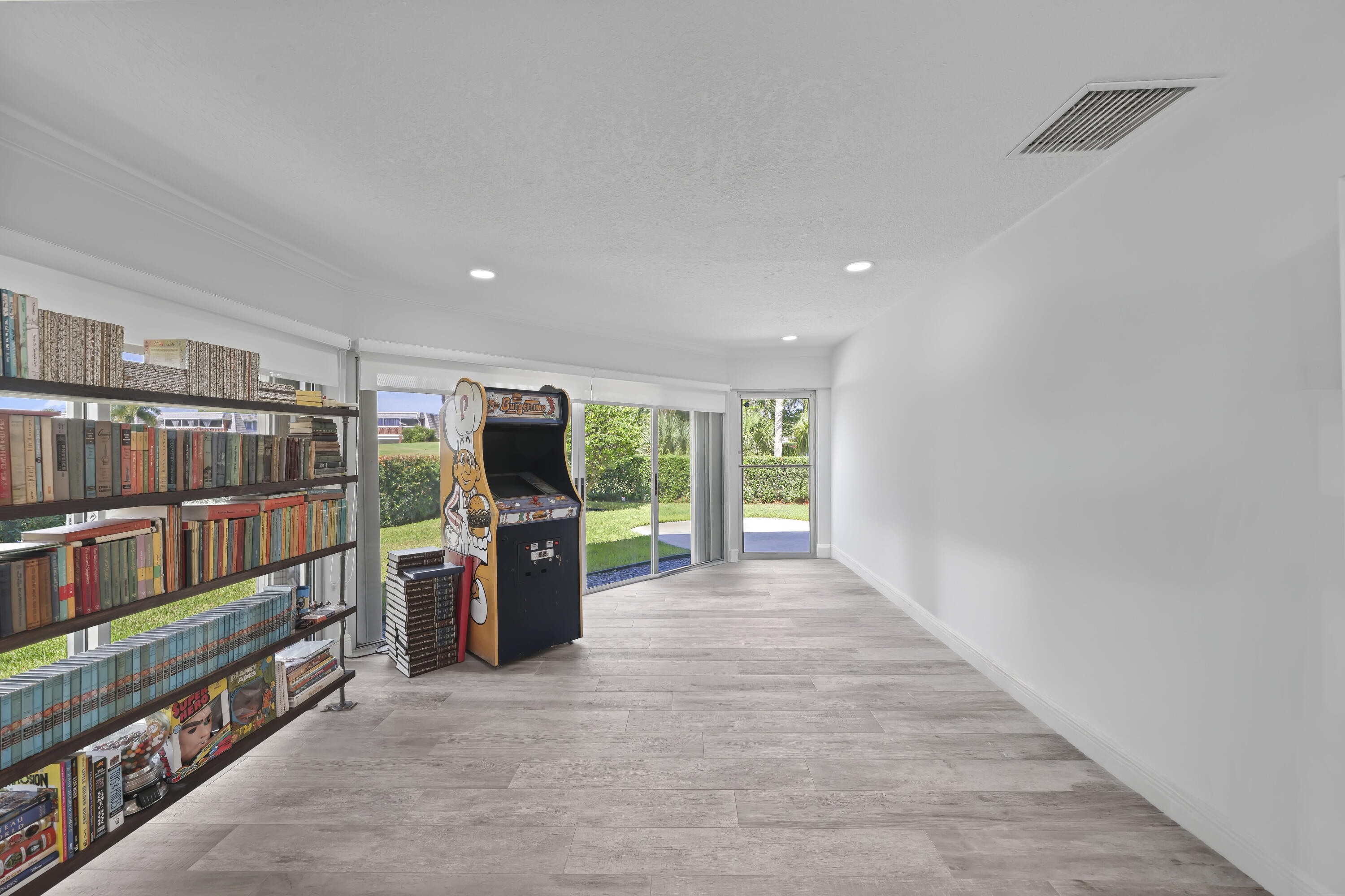 Spacious interior featuring wood-finish flooring, recessed lighting, and expansive glass sliding doors providing natural light
