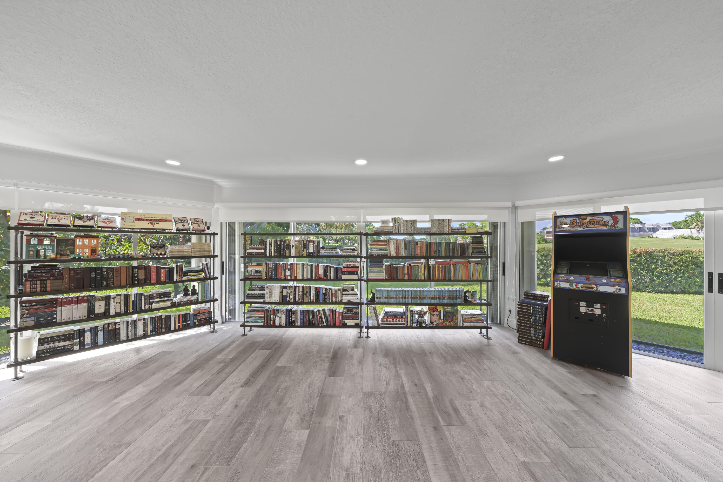 Spacious room featuring wood-finish flooring, recessed lighting, and floor-to-ceiling glass sliding doors with access to the exterior
