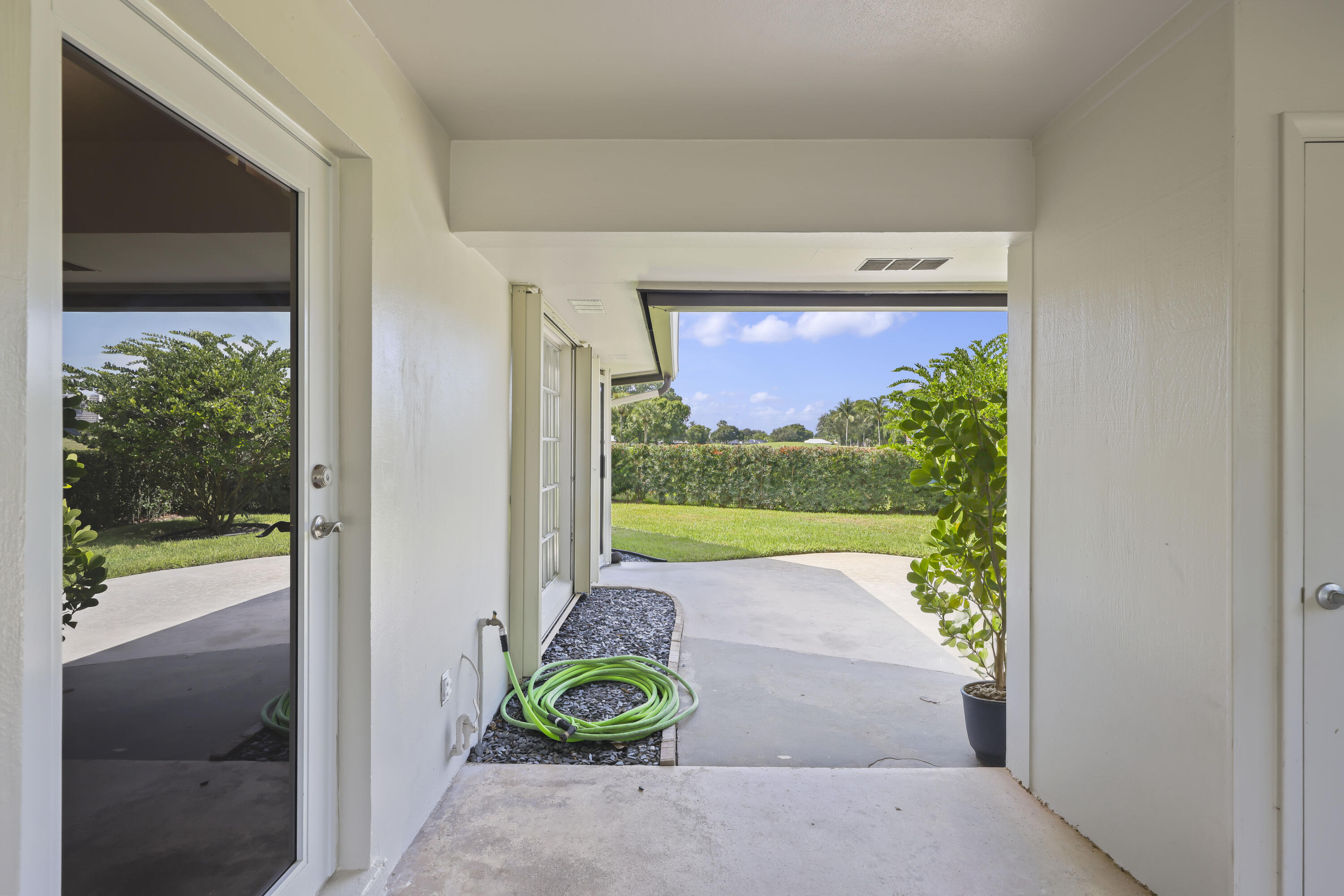 Covered patio featuring concrete flooring, external water spigot, and clear glass-pane door
