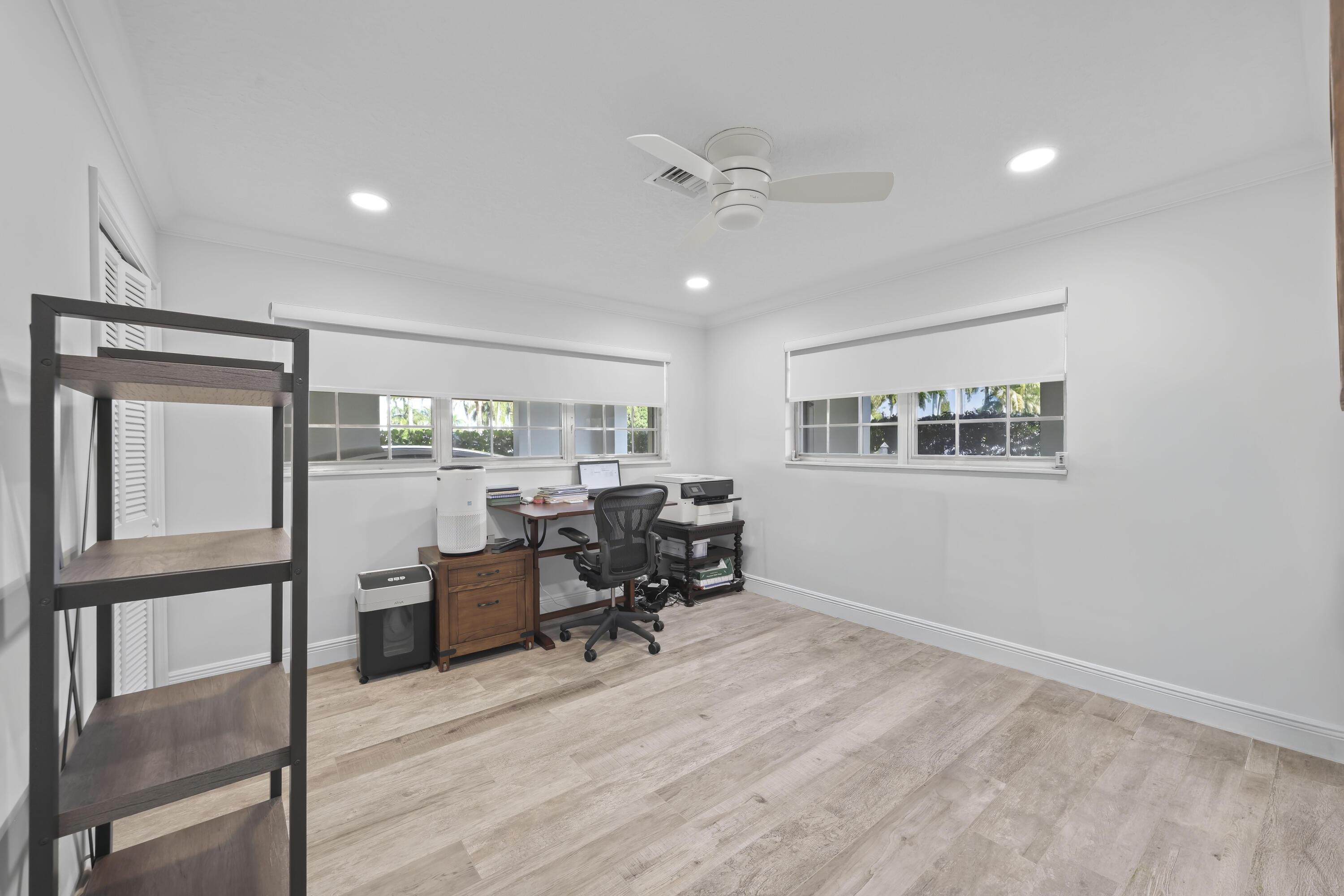 Room featuring wood-finish flooring, recessed lighting, white louvered closet doors, multi-pane windows, and a central ceiling fan