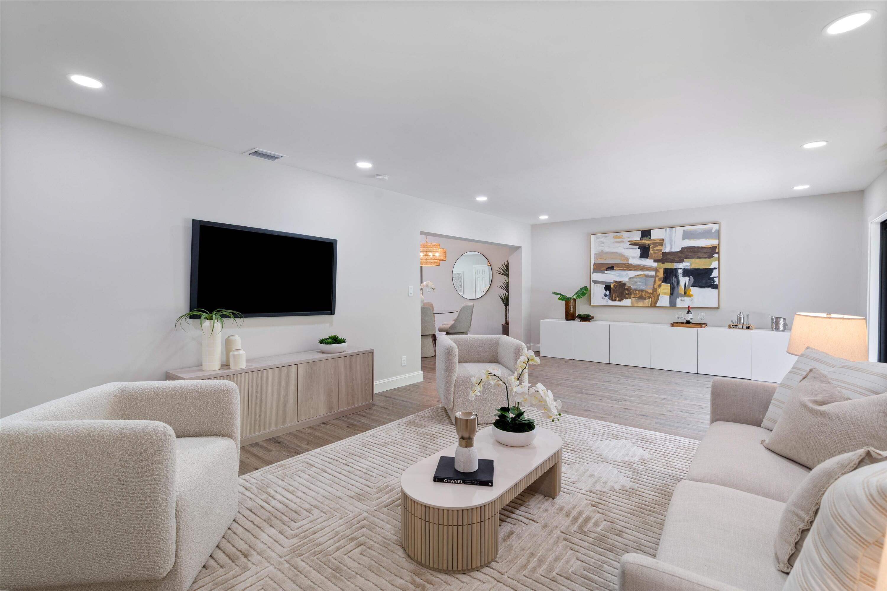 Living area featuring wood-finish flooring, recessed lighting, and built-in white cabinetry Living area featuring wood-finish flooring, recessed lighting, and built-in white cabinetry