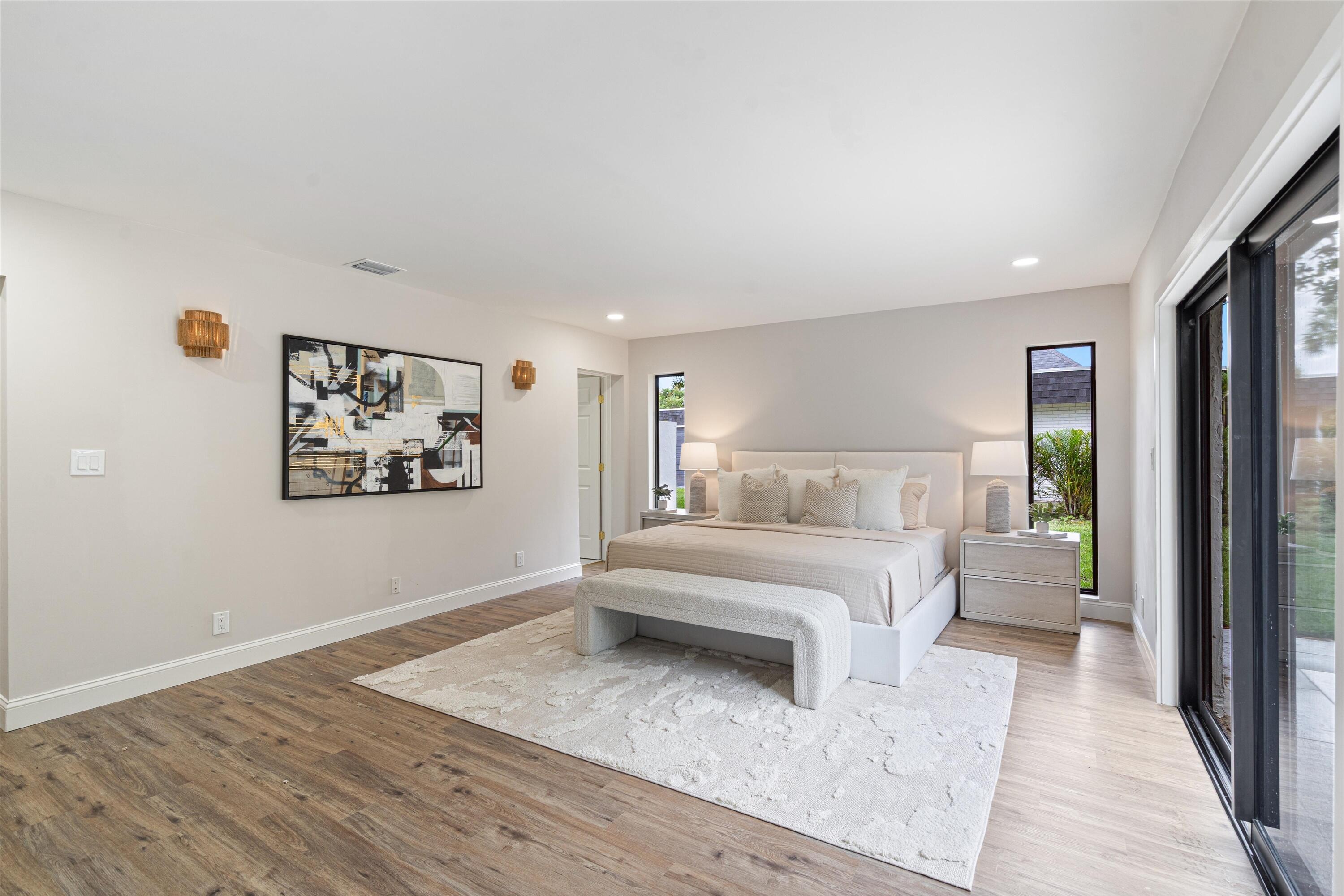 Wood-finish flooring, recessed ceiling lighting, wall-mounted light fixtures, and floor-to-ceiling sliding glass doors
