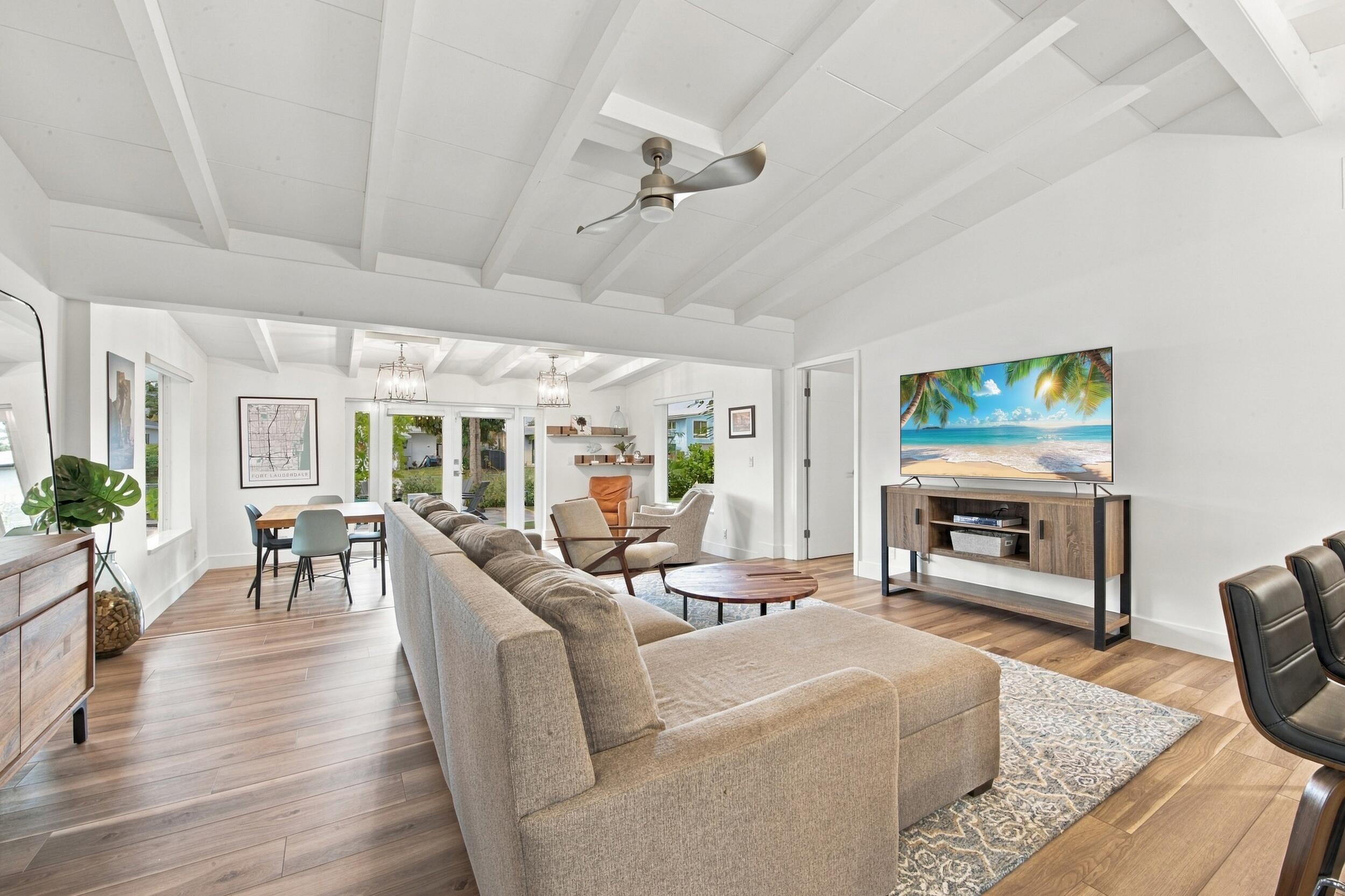 Vaulted ceilings with exposed beams, wood-finish flooring, and recessed lighting