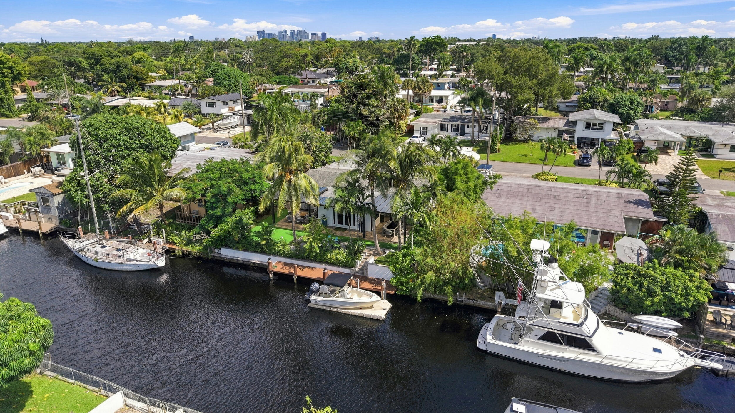 Waterfront property featuring a private bulkhead dock, mature landscaping, and direct canal access