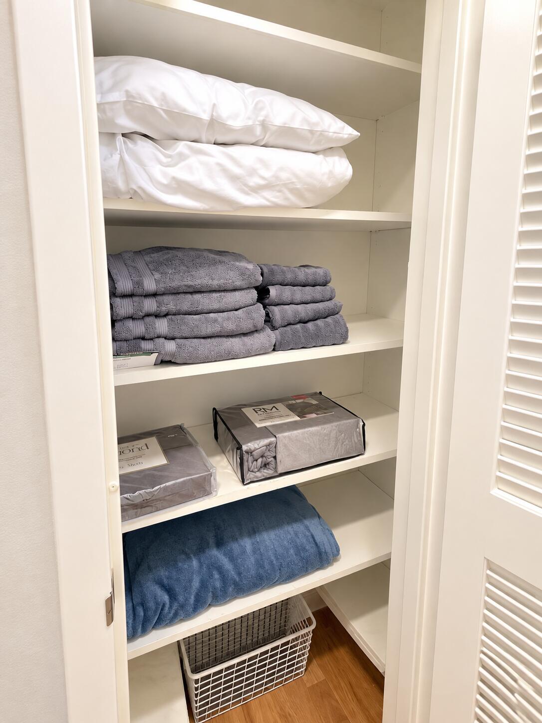 Organized Linen Closet with Blue Blanket