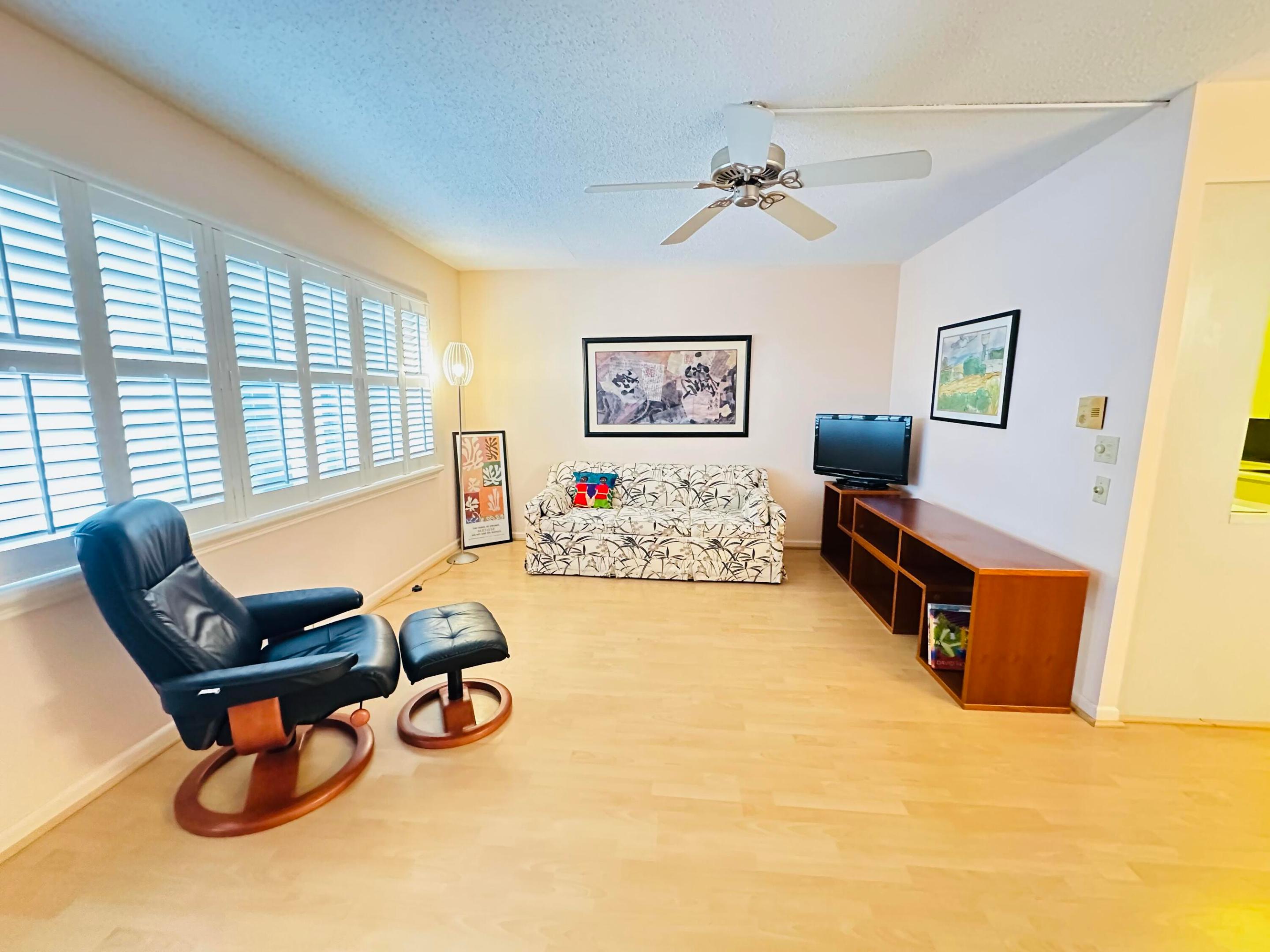 Interior space featuring light laminate flooring, plantation shutters, and a ceiling fan Interior space featuring light laminate flooring, plantation shutters, and a ceiling fan