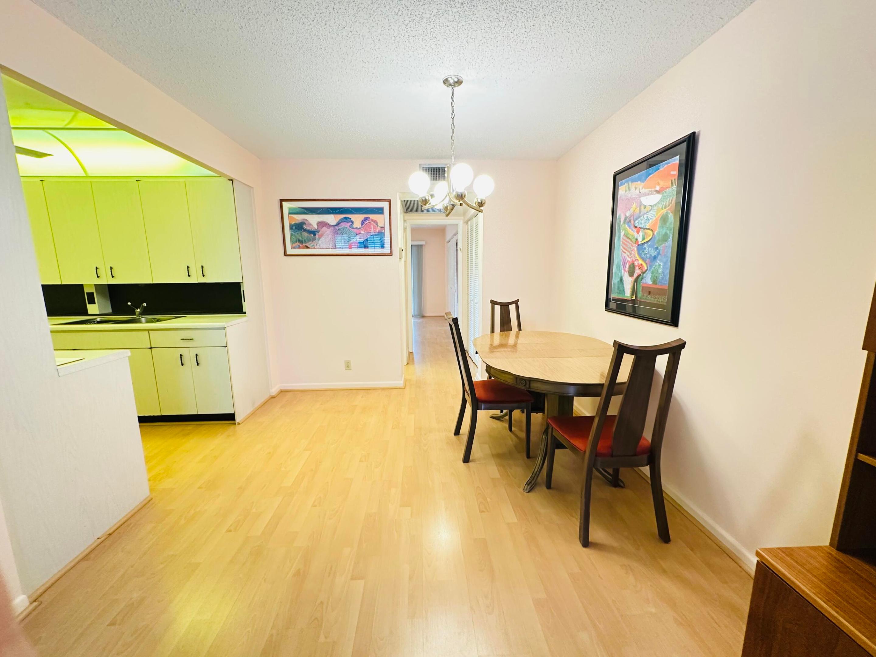 Dining area featuring light-toned laminate flooring and a multi-globe chandelier Dining area featuring light-toned laminate flooring and a multi-globe chandelier