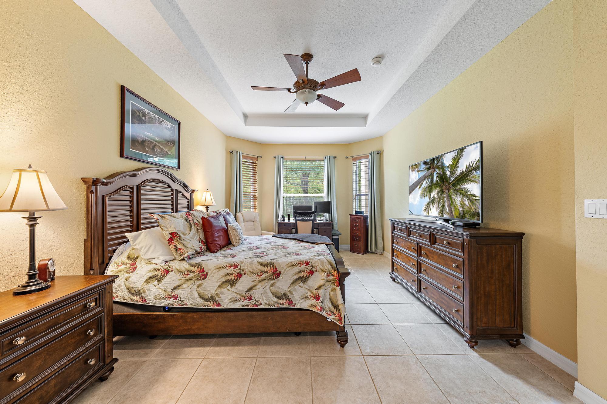 Tray ceiling, expansive tile flooring, and a bay window configuration