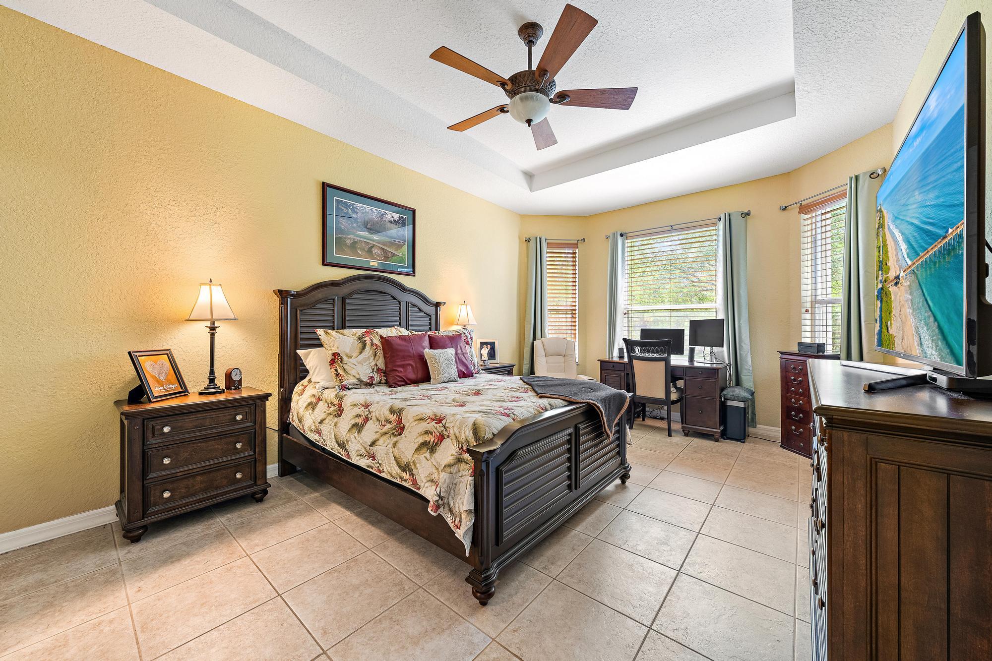 Tray ceiling, expansive tile flooring, and a bay window.