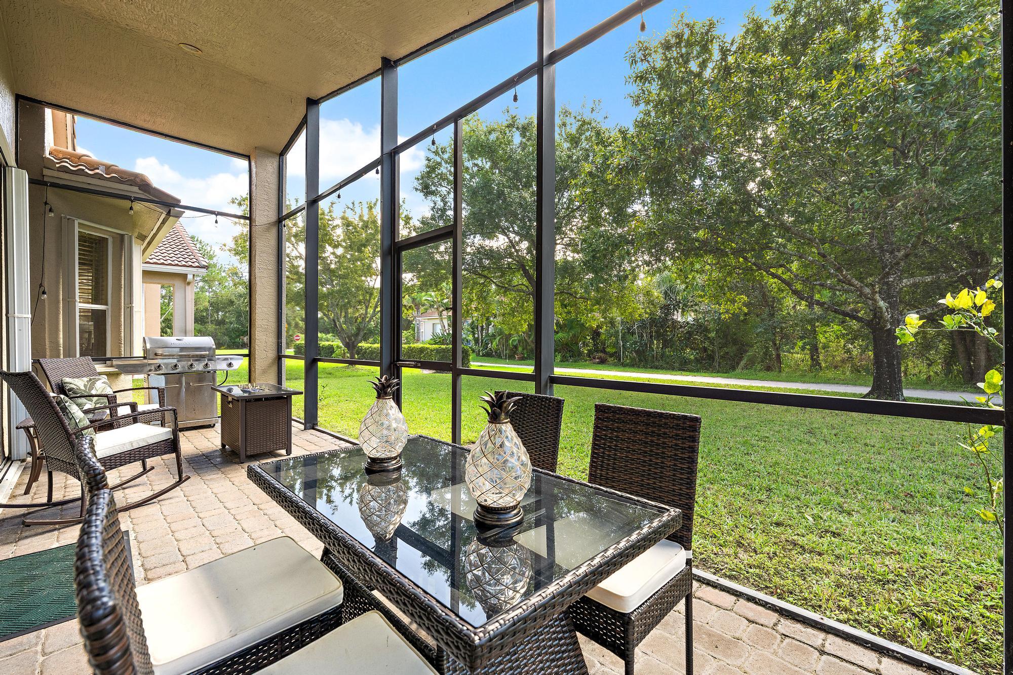 Screened lanai featuring paver flooring, a covered ceiling, and a built-in outdoor cooking area