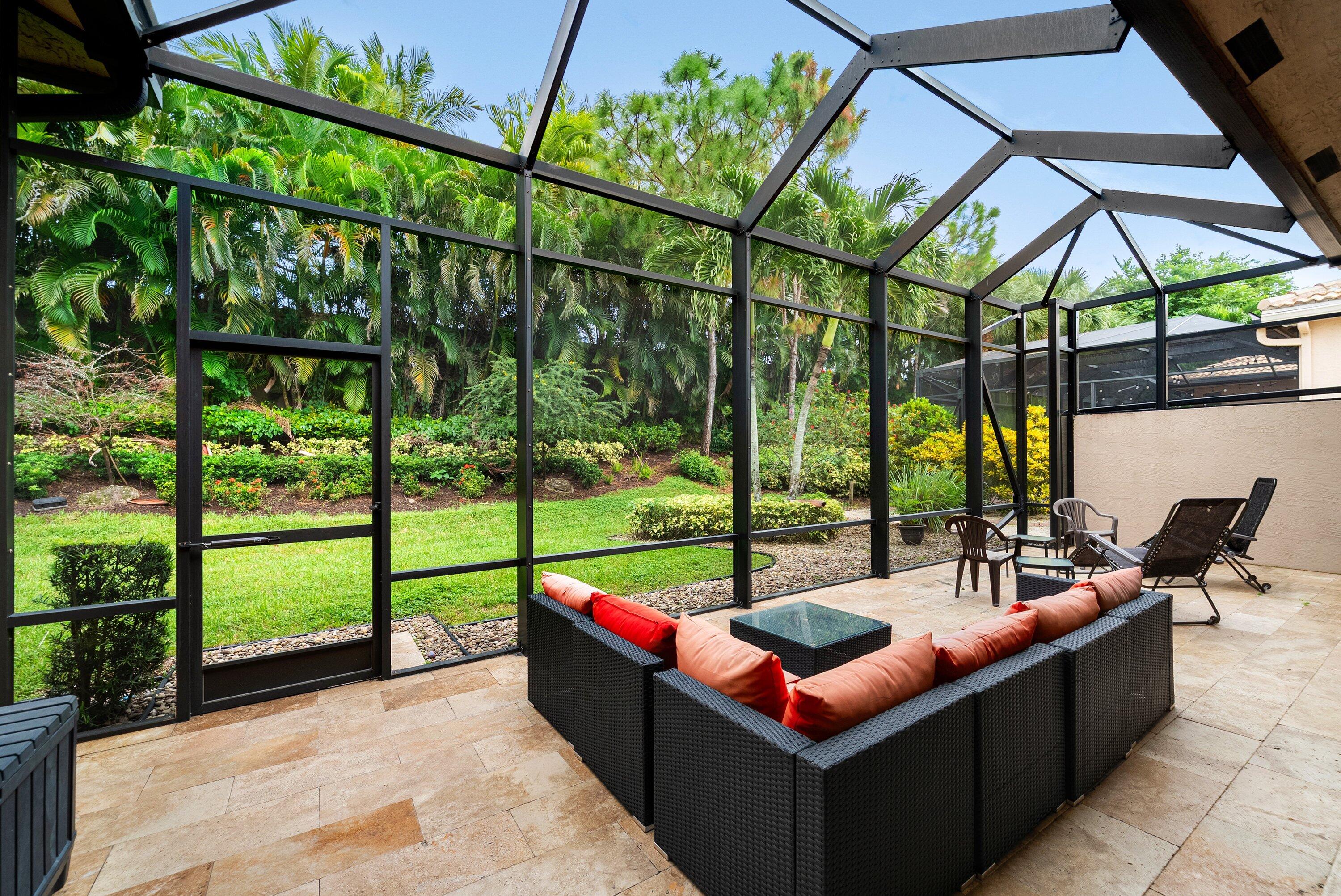 Screened-in patio enclosure featuring stone flooring and metal structural framing
