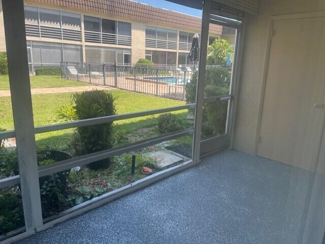 Screened-in patio featuring textured epoxy flooring and a metal-framed door