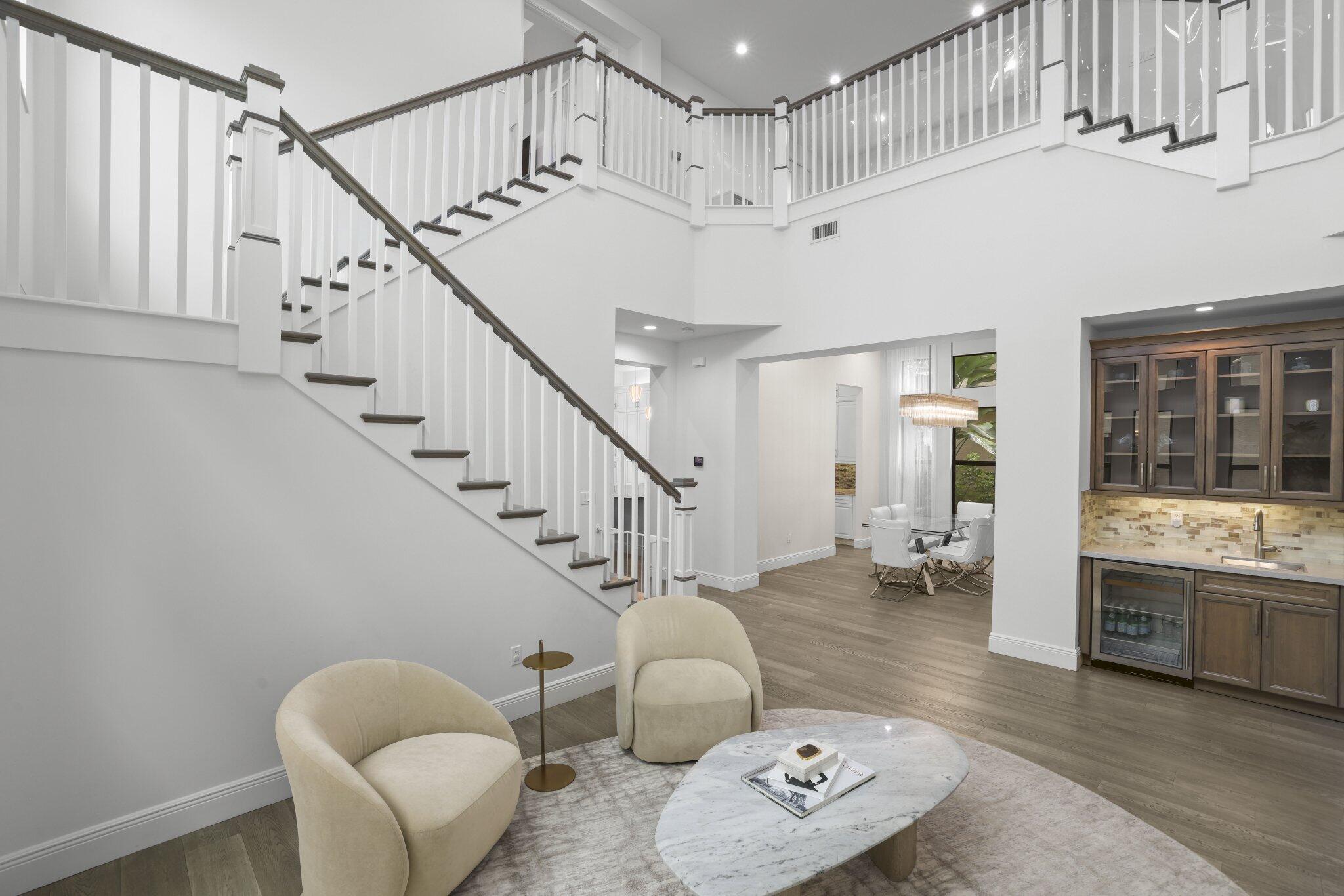 Two-story foyer with a grand staircase and wood-finish flooring