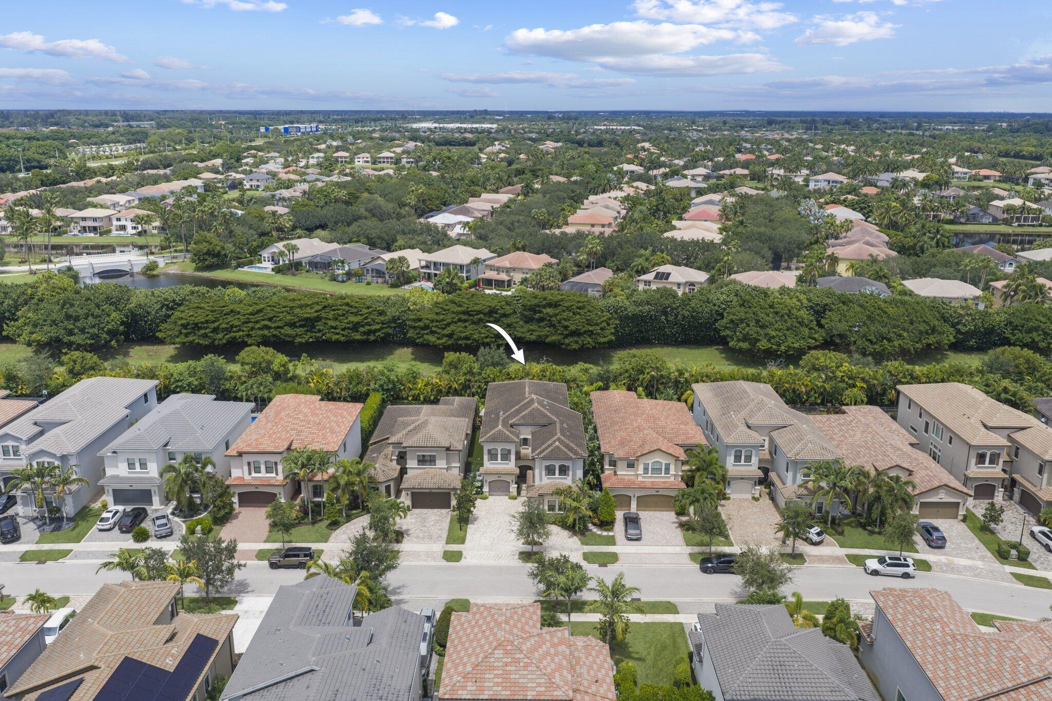 Two-story residential architecture with a tiled roof, paver driveway, and a front-facing garage