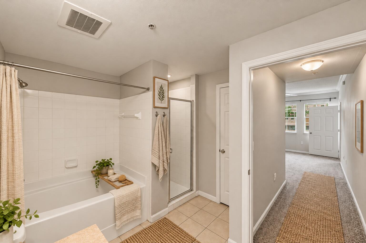 Bathroom featuring a tiled shower-tub combination, separate glass-enclosed shower, neutral wall tones, and tile flooring