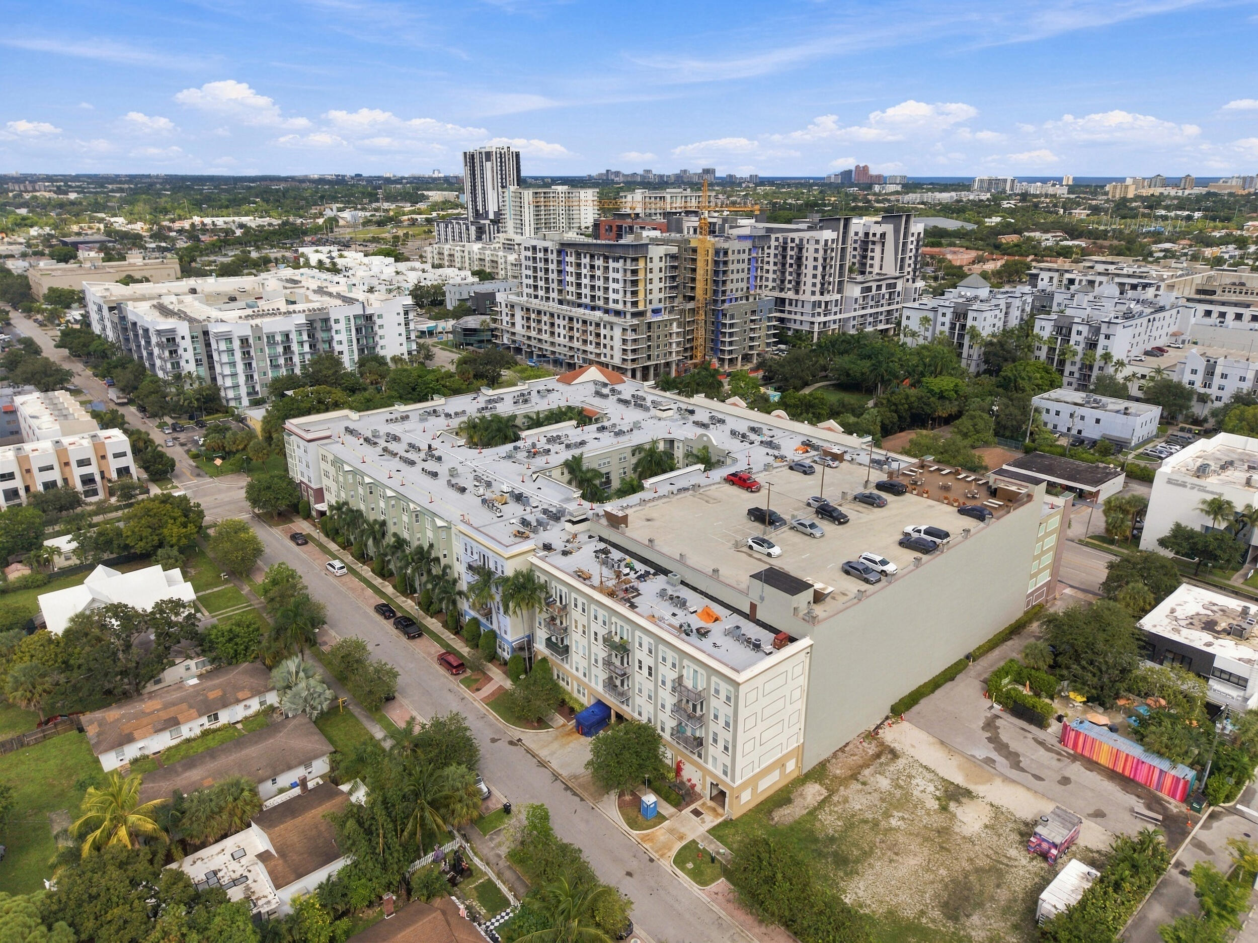 Multi-story residential complex featuring a rooftop parking deck, central courtyard, and exterior balconies
