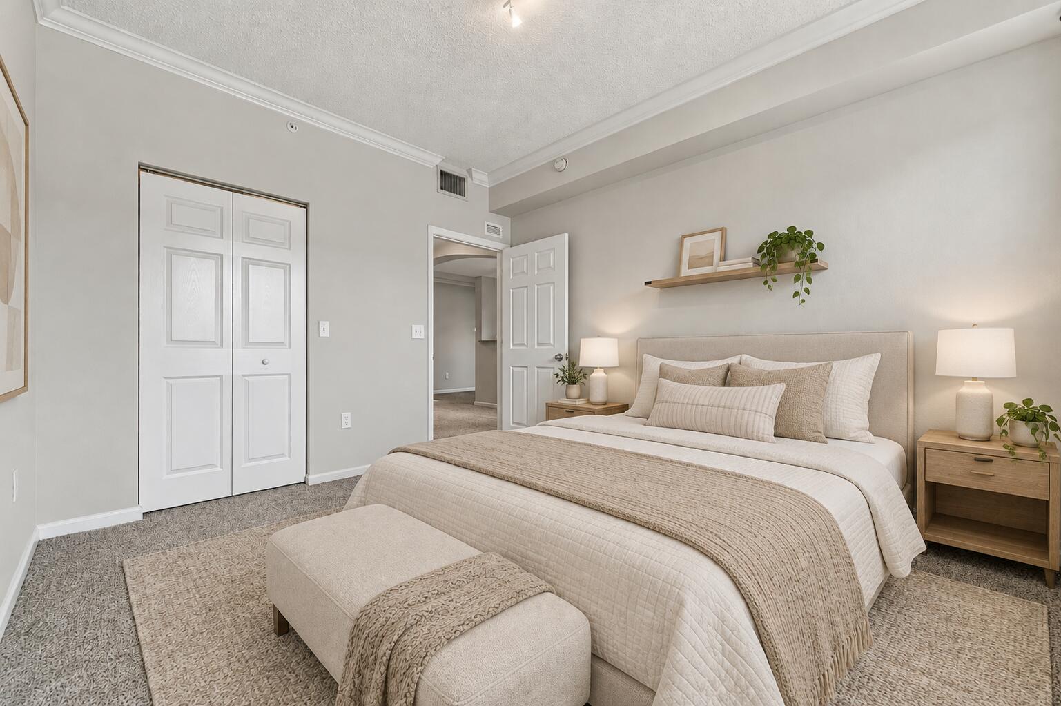 Bedroom featuring neutral wall paint, crown molding, wall-to-wall carpeting, and a built-in wall shelf