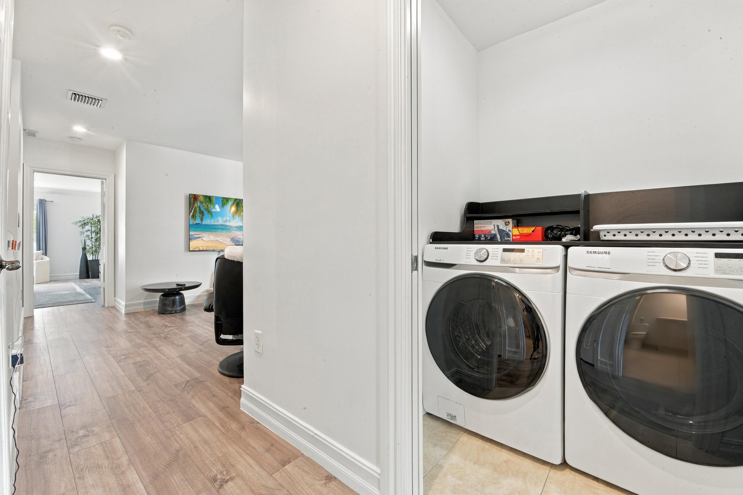Laundry alcove featuring wood-finish flooring, recessed lighting, and built-in upper shelving