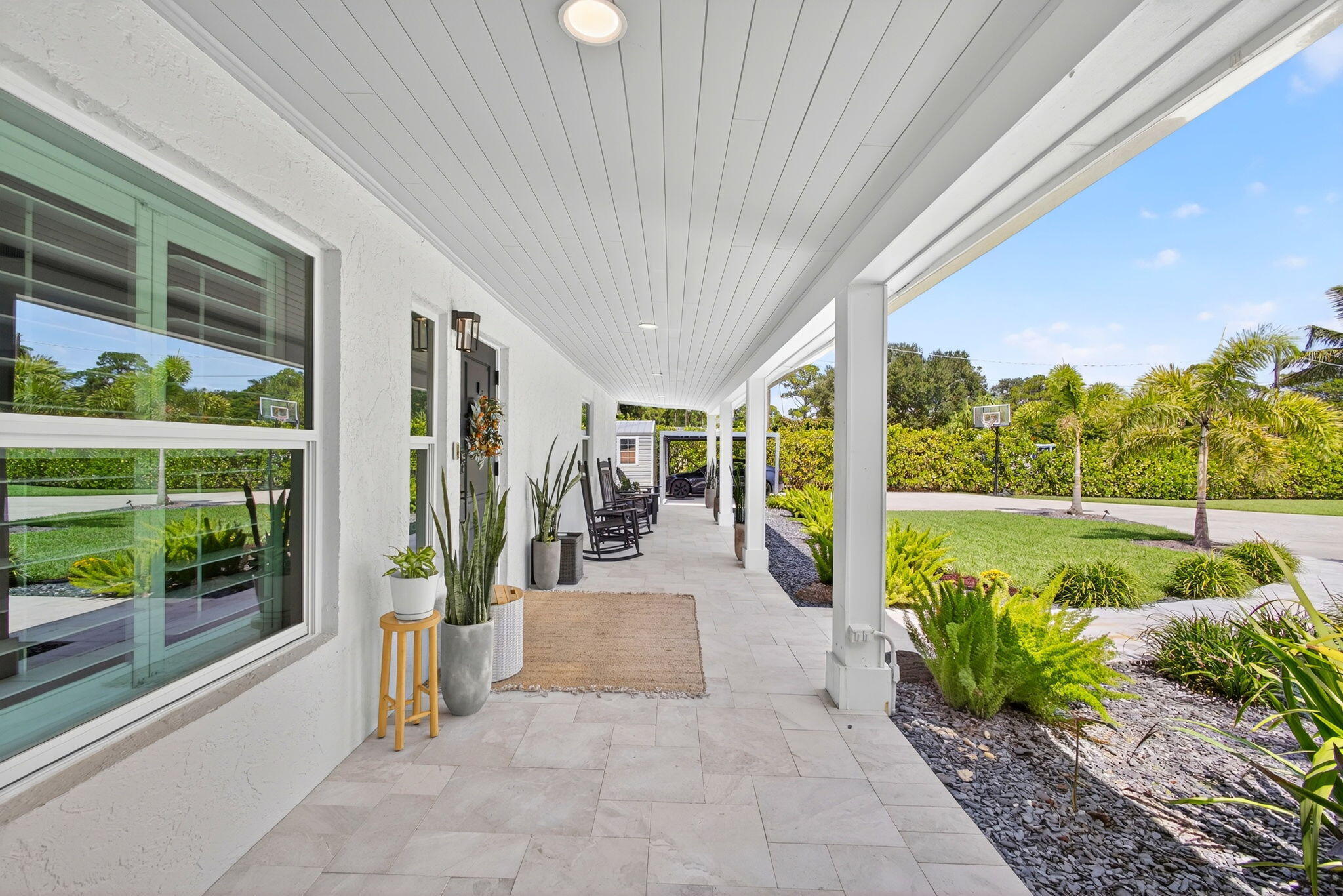 Covered porch featuring light-toned tile flooring, beadboard ceiling, recessed lighting, and white support columns
