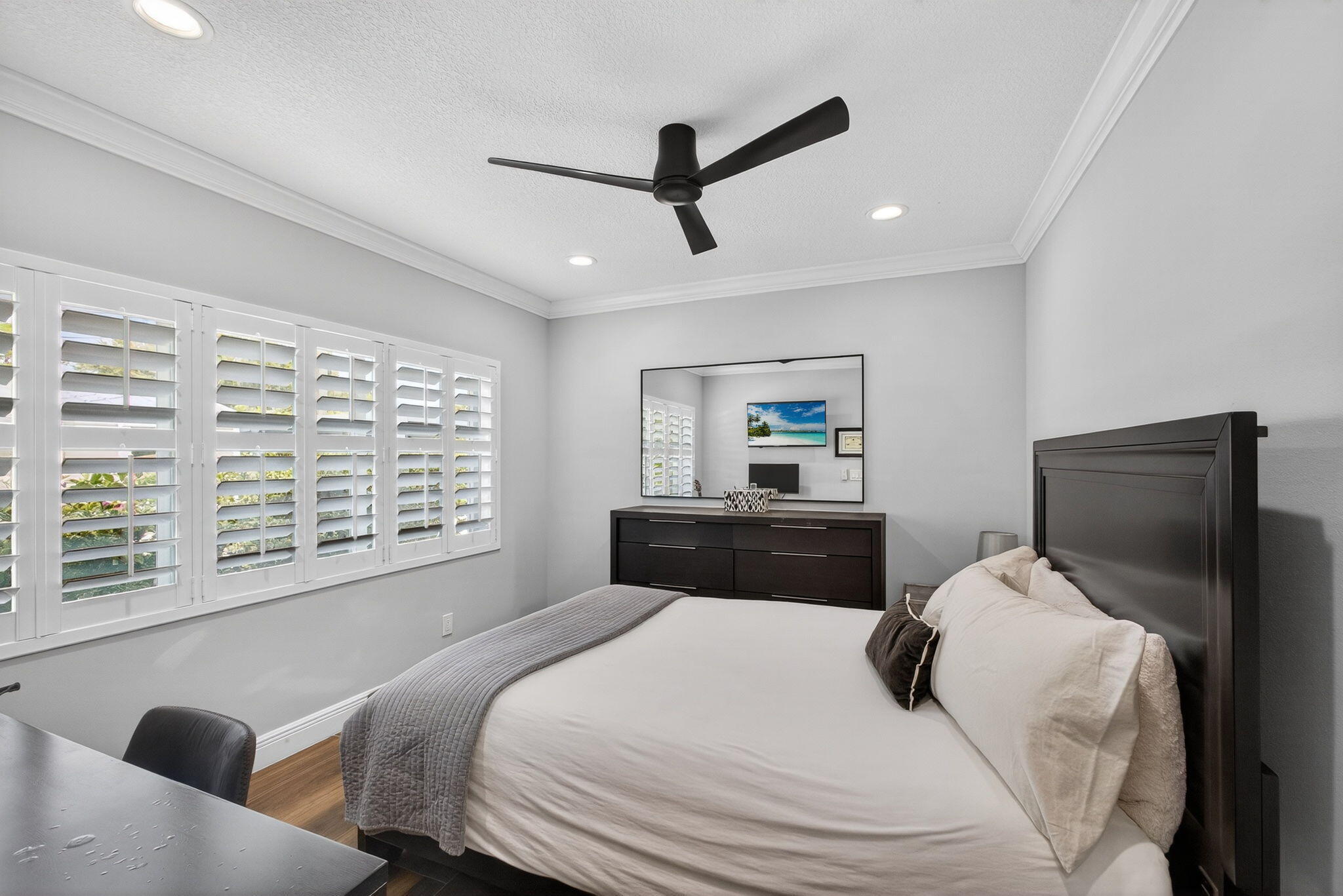 Room featuring wood-finish flooring, crown molding, plantation shutters, a contemporary ceiling fan, and recessed lighting