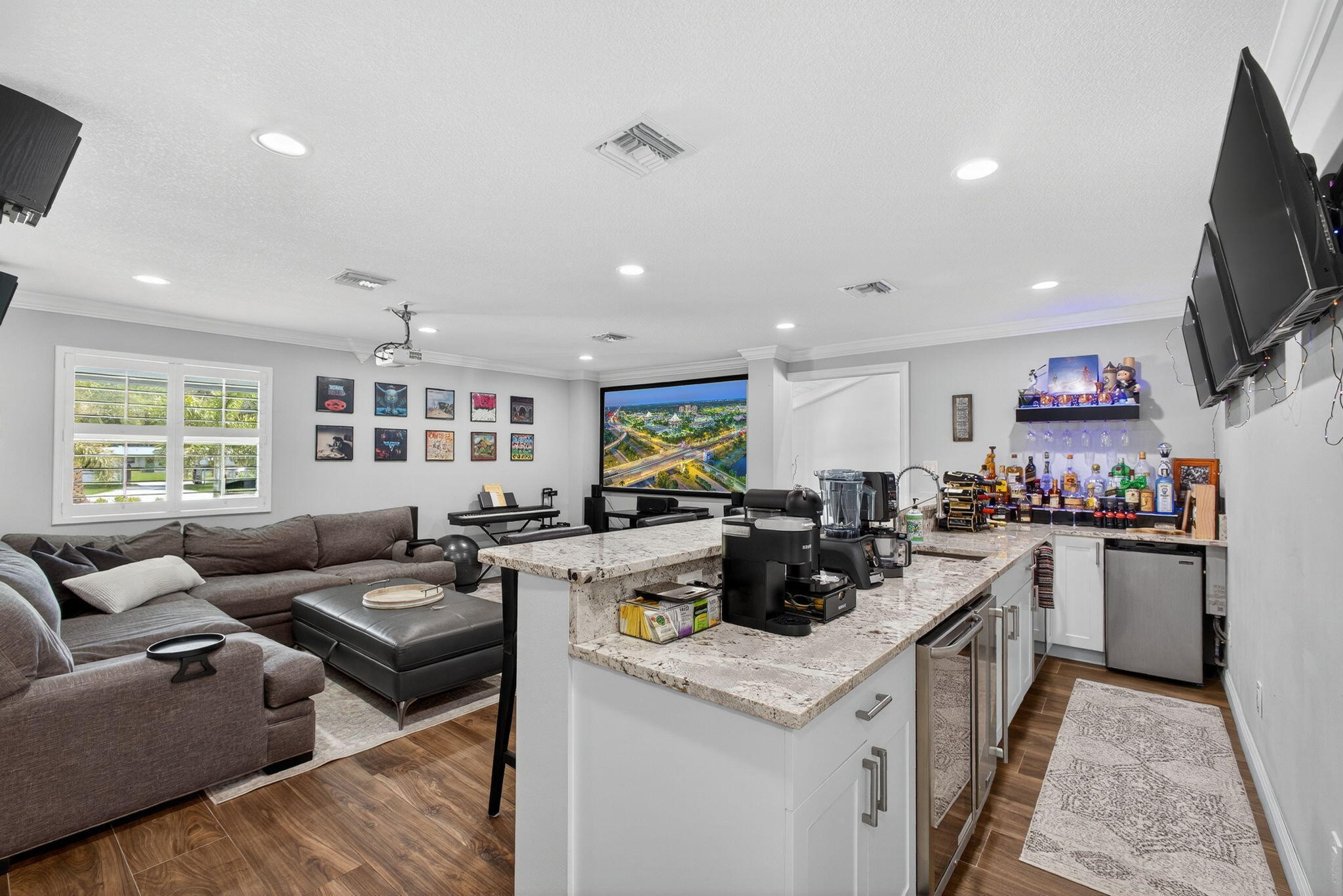 Spacious room featuring wood-finish flooring, recessed lighting, and crown molding