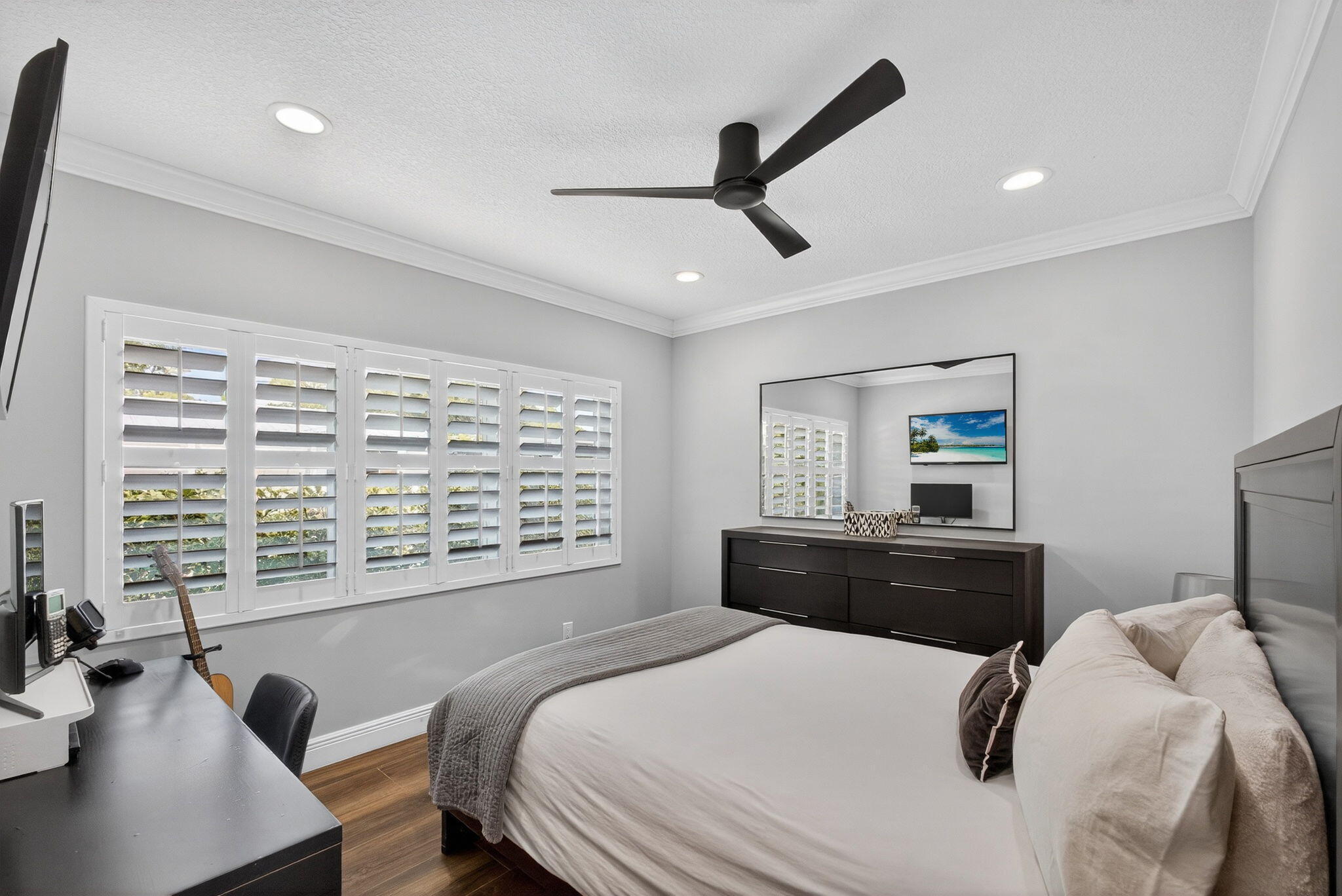 Wood-finish flooring, plantation shutters, crown molding, recessed lighting, and a modern ceiling fan