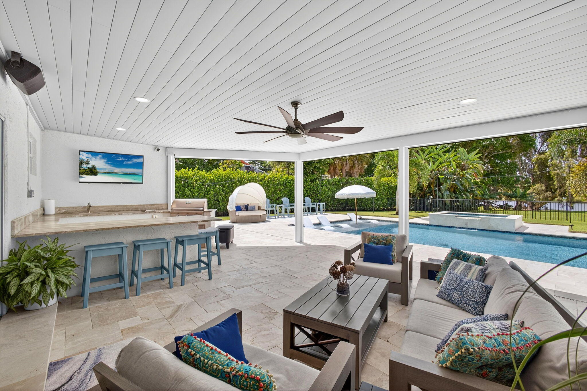 Covered patio featuring stone-tile flooring, a built-in outdoor kitchen with a stone countertop, a ceiling fan, recessed lighting, and a swimming pool with an attached spa