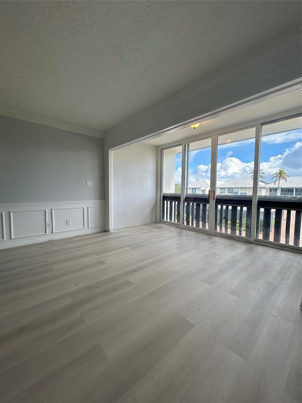 Balcony/ Florida Room/ Office space connected to Living/ Family room. Sliding doors were removed to connect the space for more usage. Window treatments / dividers can be added to separate the rooms.Brand new flooring just installed. Custom moldings (wainscoting) / wood work throughout the unit. View from balcony/ patio/ sun room looks over the St. Lucie River, pier, club house, pool, and shuffle board.