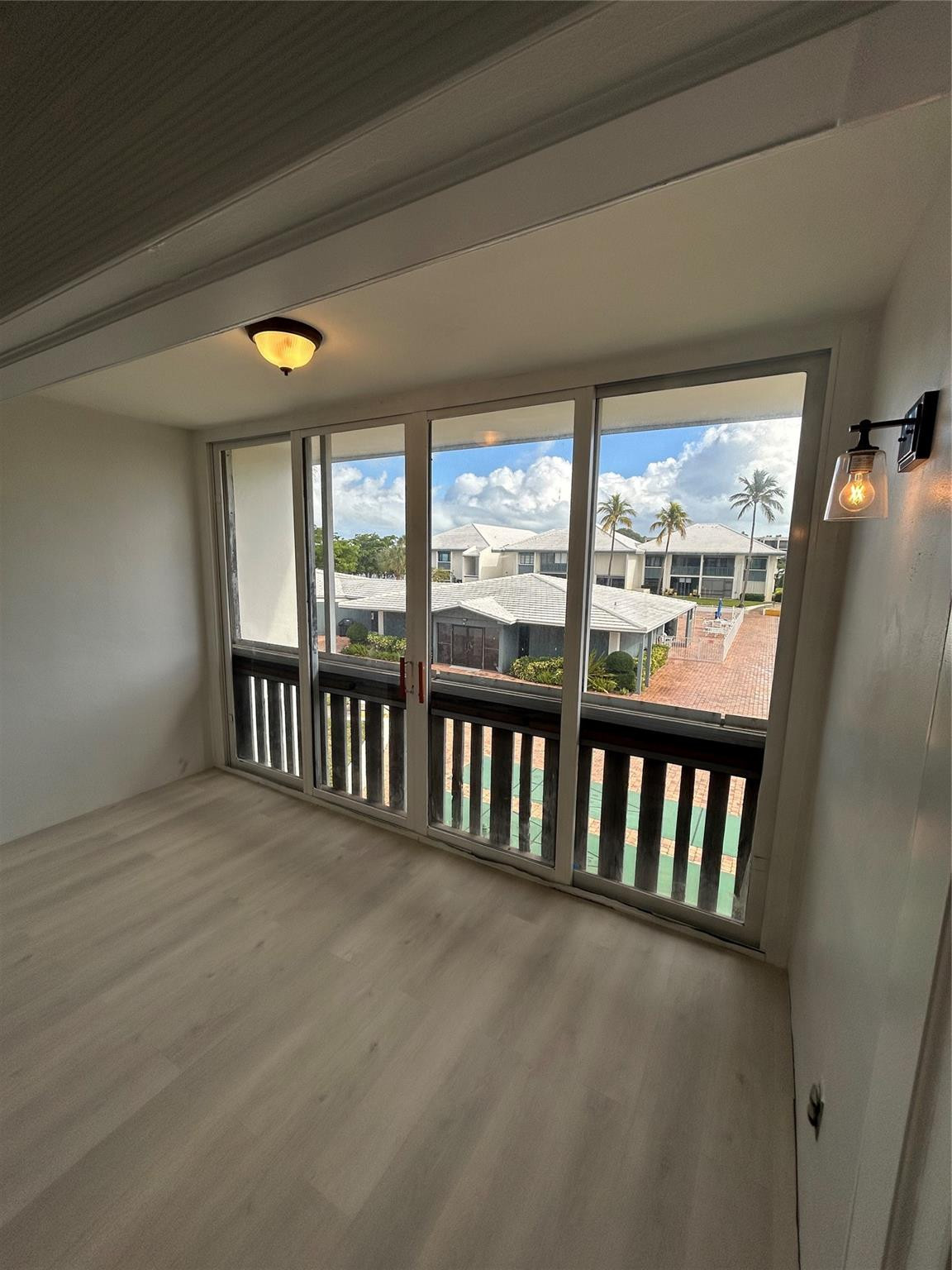 Balcony/ Florida Room/ Office space connected to Living/ Family room. Sliding doors were removed to connect the space for more usage. Window treatments / dividers can be added to separate the rooms.Brand new flooring just installed. Custom moldings (wainscoting) / wood work throughout the unit. View from balcony/ patio/ sun room looks over the St. Lucie River, pier, club house, pool, and shuffle board.