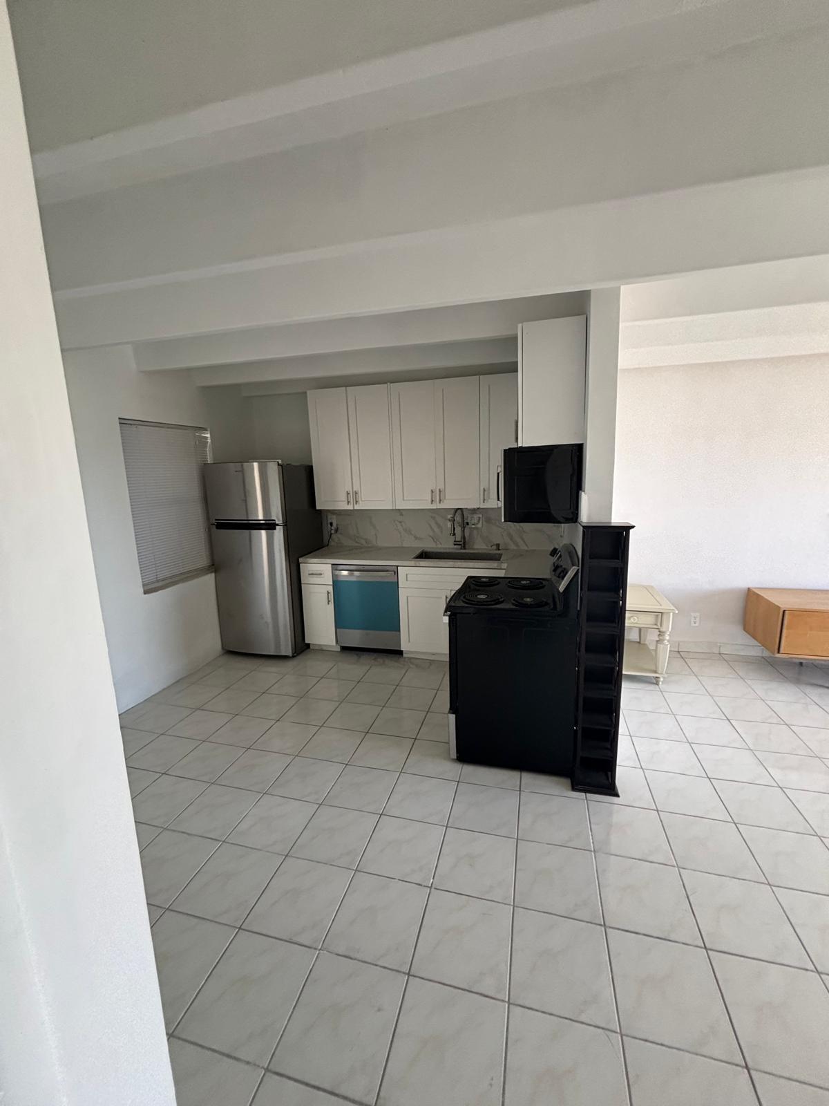 Kitchen featuring white cabinetry, tile flooring, stainless steel refrigerator, dishwasher, and stove