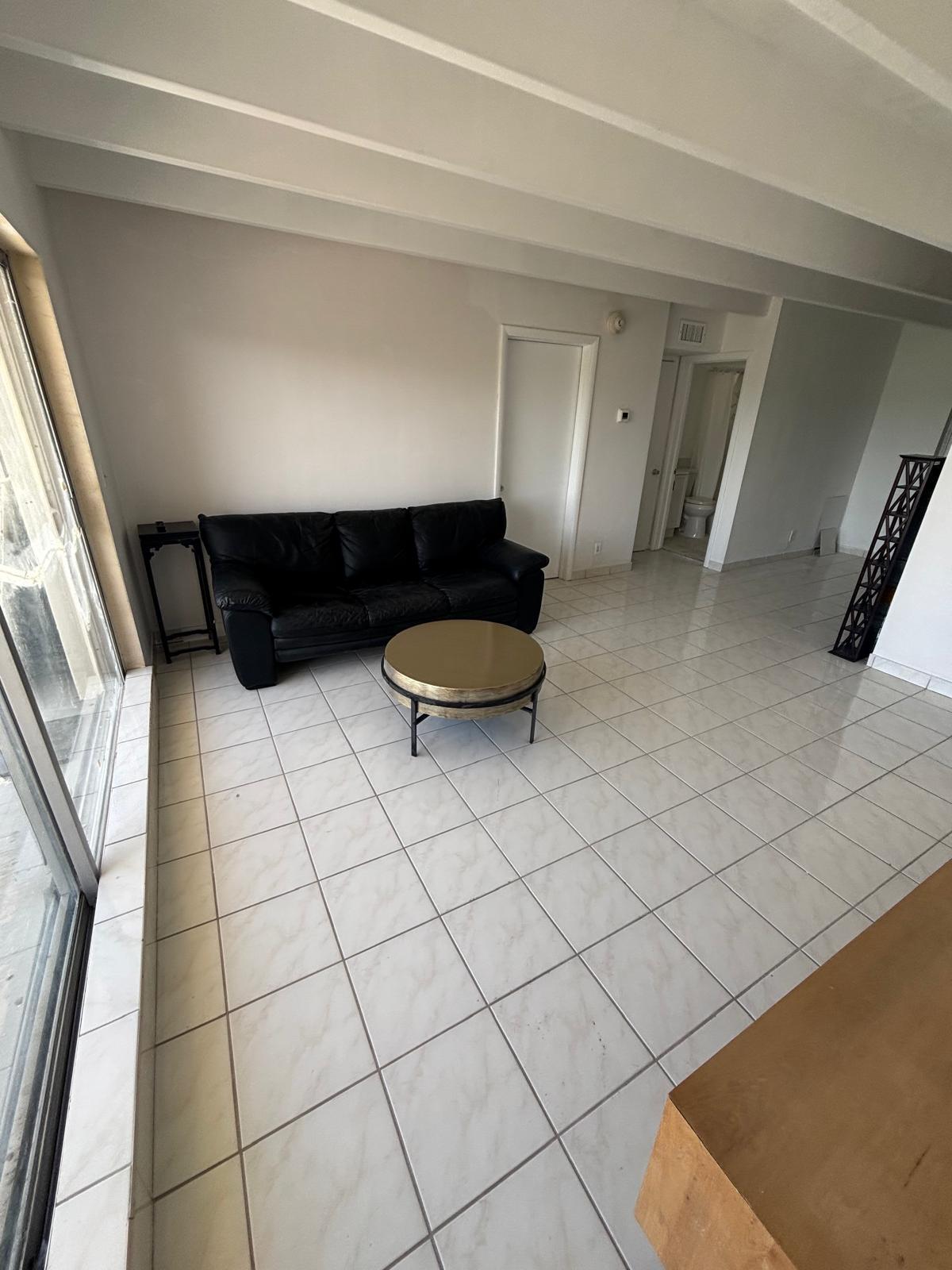 Large-format tile flooring, exposed structural ceiling beams, and floor-to-ceiling glass sliding doors