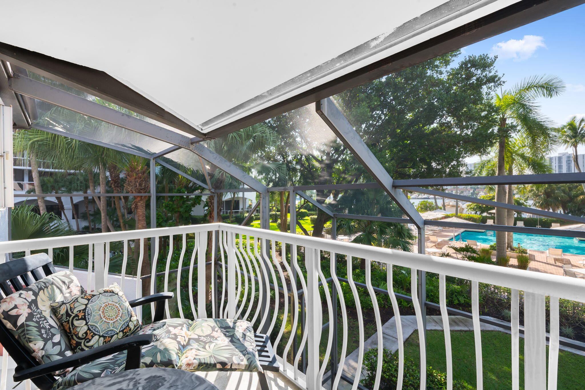 Screened-in balcony in primary bedroom featuring a white metal railing and a solid roof covering