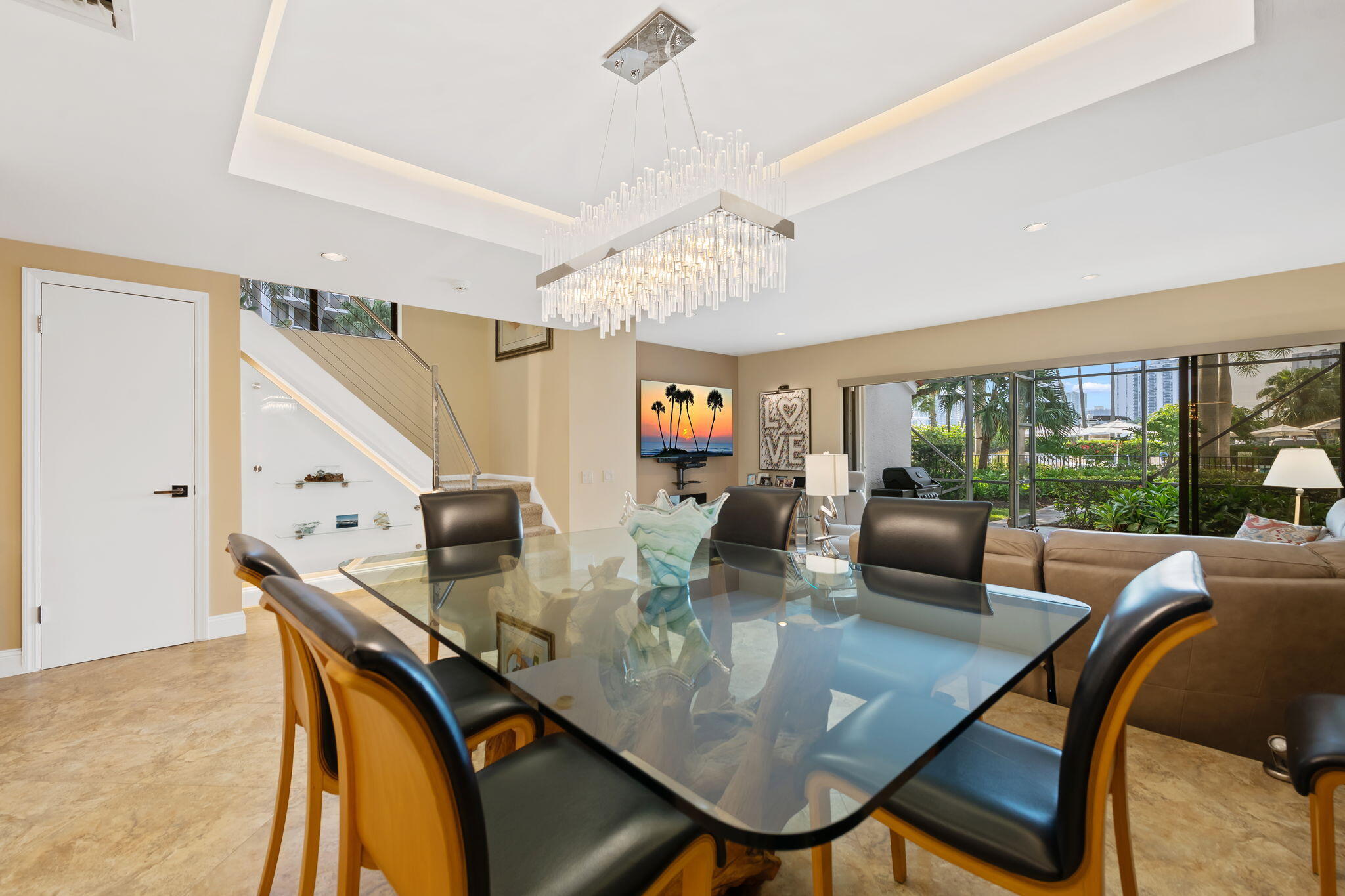 Tray ceiling with recessed lighting, tile flooring, and retractable glass sliding doors