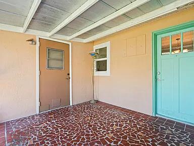 Screened patio. Turquoise Door is back door entry to left side unit. Brown door is to joined laundry area.