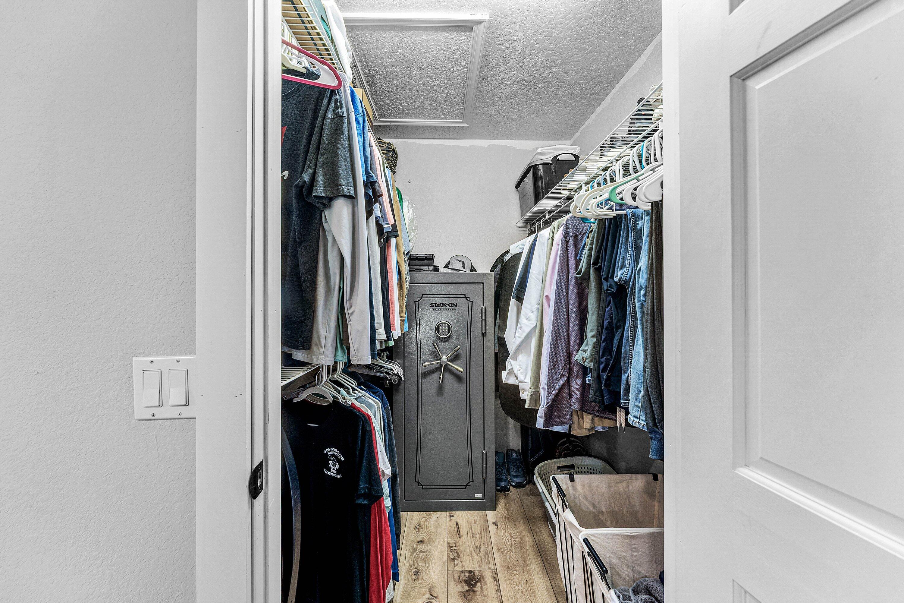 Walk-in storage area featuring wood-finish flooring and tiered wire shelving